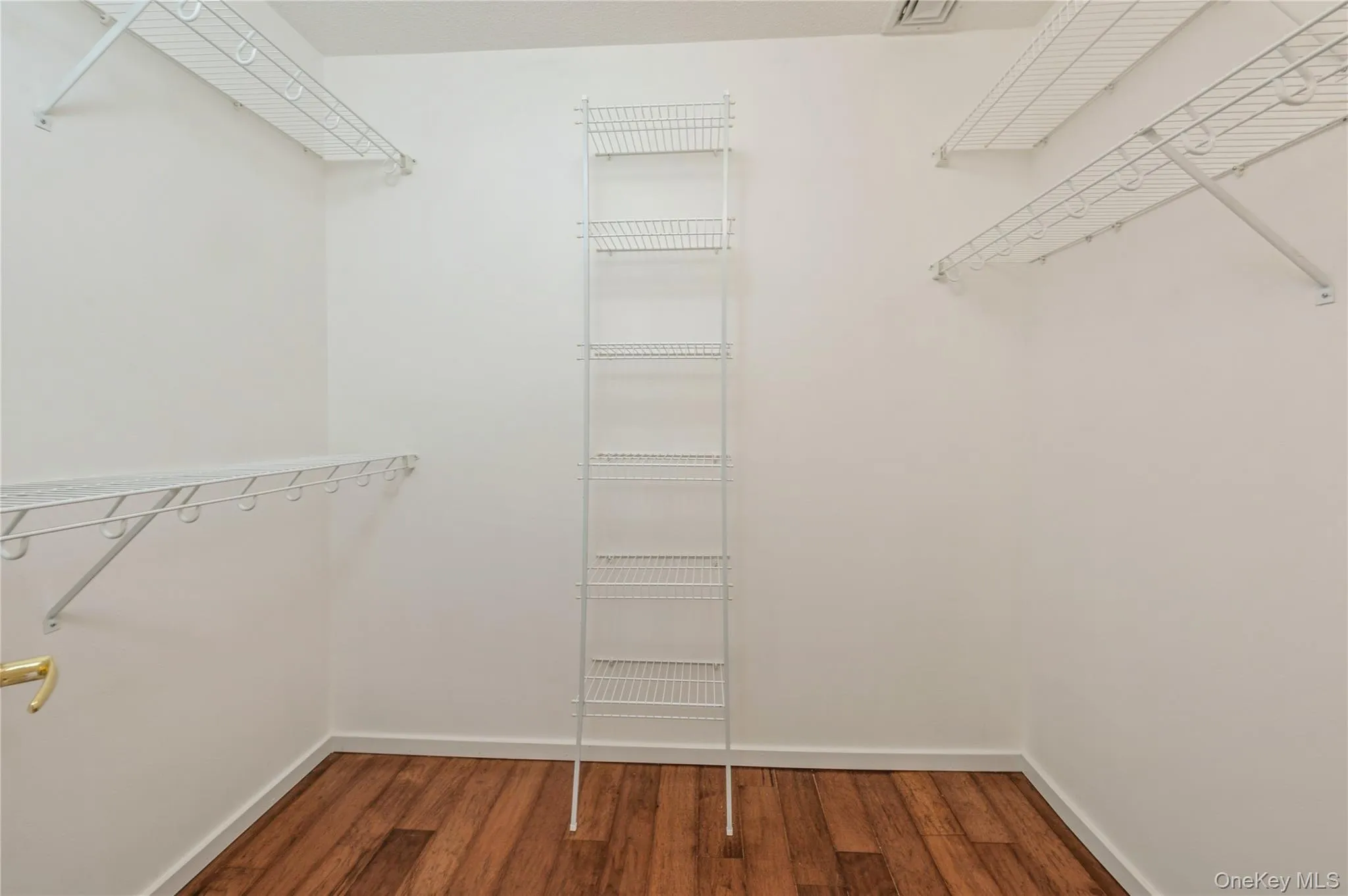Walk in closet featuring wood finished floors Walk in closet featuring wood finished floors