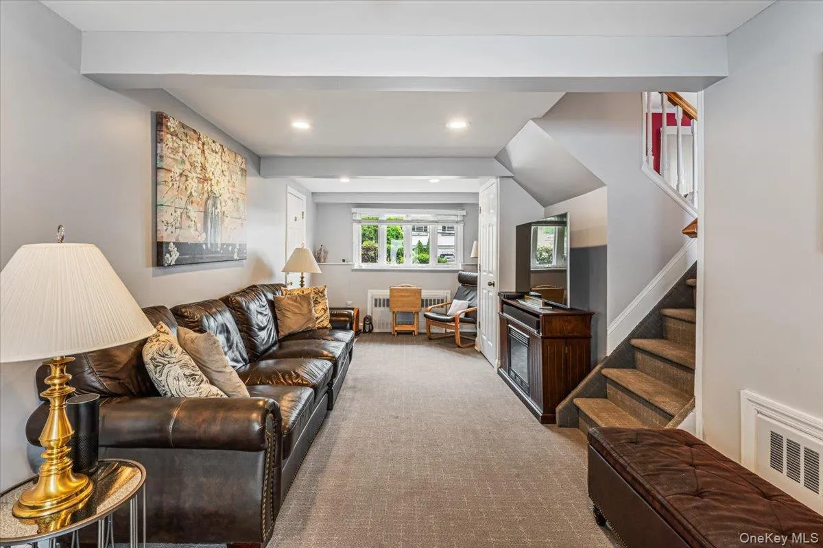 Carpeted room featuring light gray walls, recessed lighting, and a staircase with carpeted treads Carpeted room featuring light gray walls, recessed lighting, and a staircase with carpeted treads
