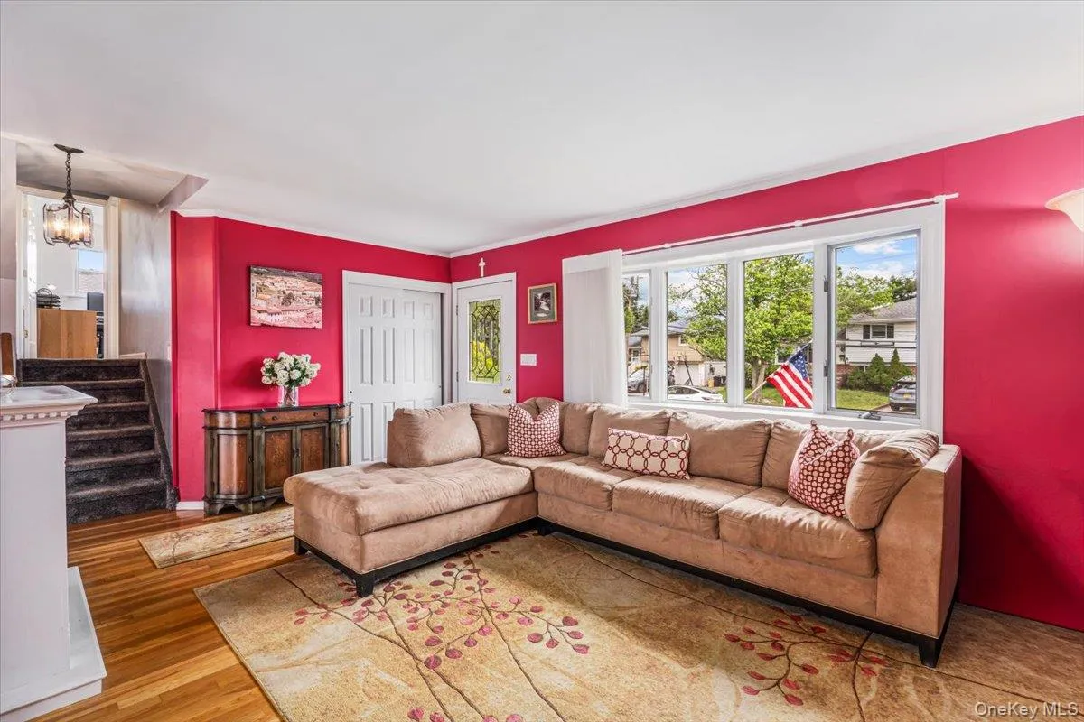 Living area featuring hardwood flooring, a large multi-pane window, and a white interior door Living area featuring hardwood flooring, a large multi-pane window, and a white interior door