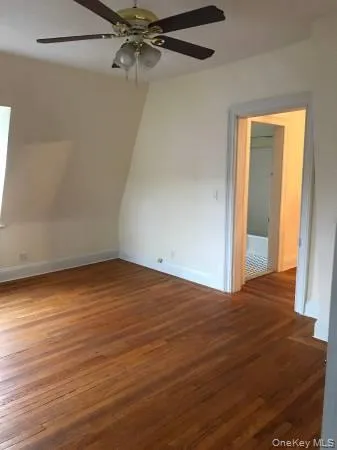 Empty room featuring baseboards, wood finished floors, and a ceiling fan Empty room featuring baseboards, wood finished floors, and a ceiling fan