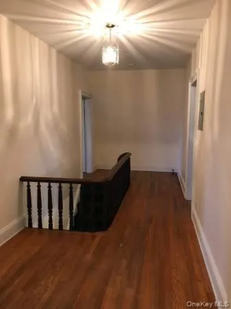 Corridor with dark wood-style floors and baseboards Corridor with dark wood-style floors and baseboards