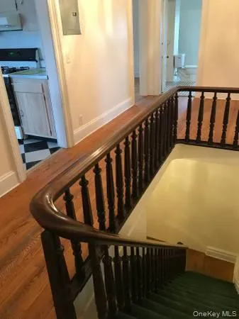 Stairway featuring baseboards, wood finished floors, and electric panel Stairway featuring baseboards, wood finished floors, and electric panel