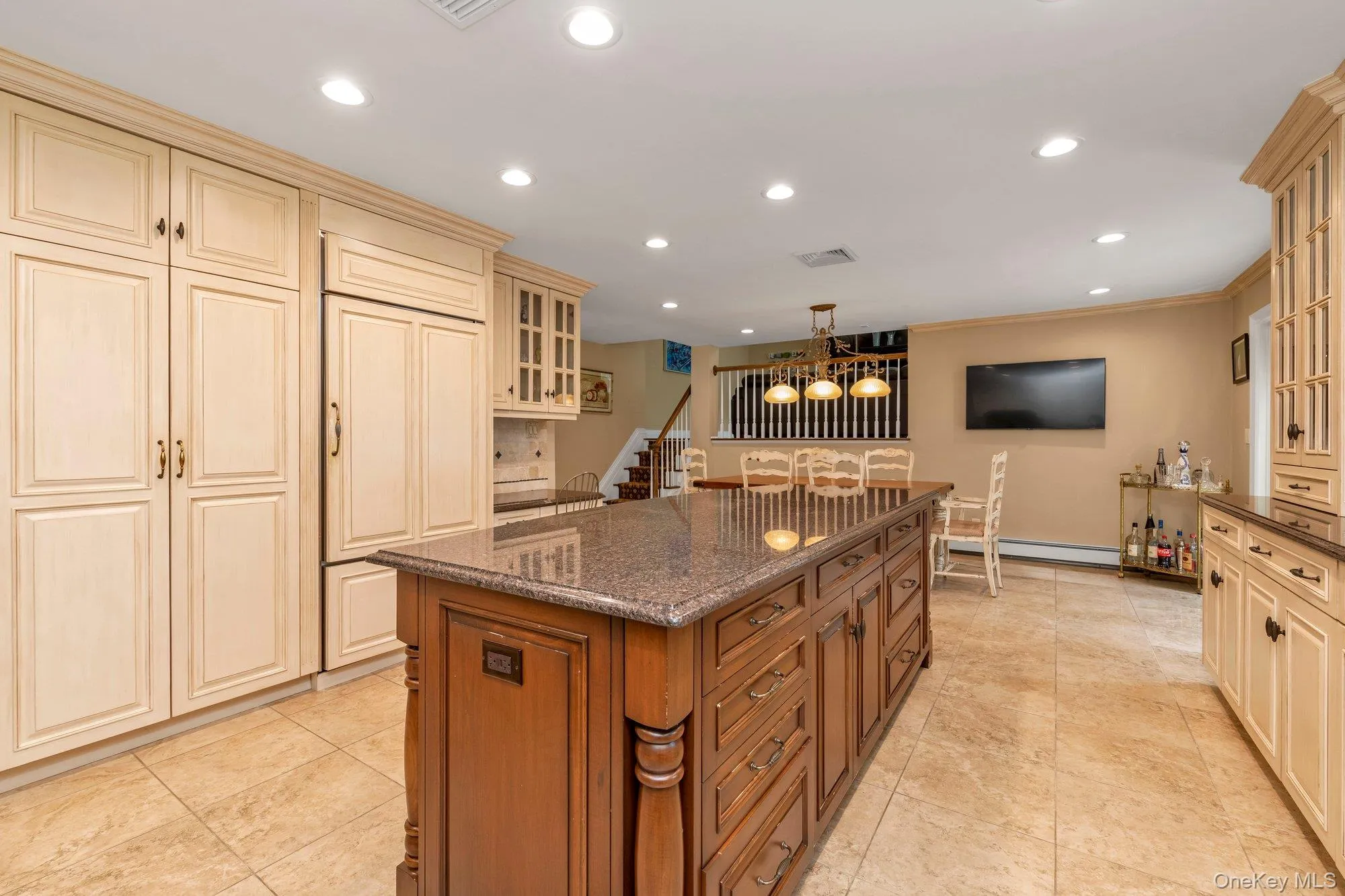 Central kitchen island with granite countertop and wood-finish cabinetry Central kitchen island with granite countertop and wood-finish cabinetry
