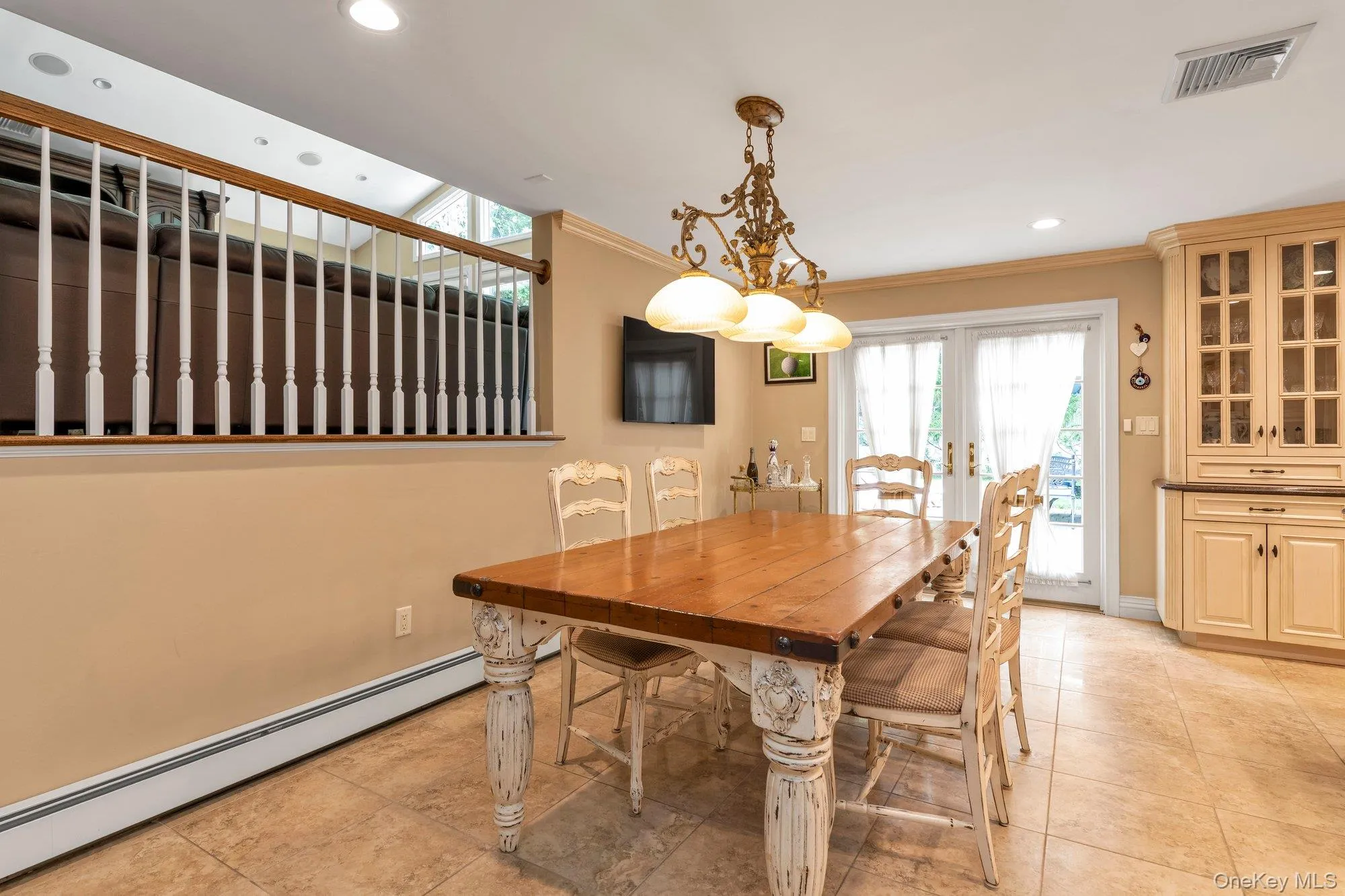 Dining area featuring a rustic wood table, a chandelier, and tiled flooring Dining area featuring a rustic wood table, a chandelier, and tiled flooring