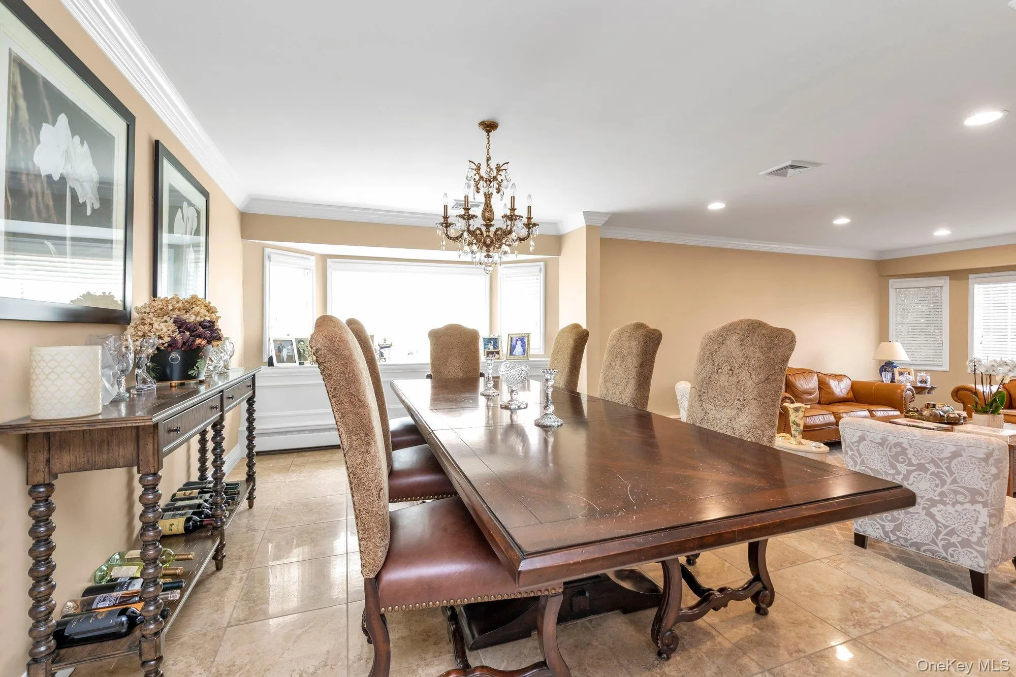 Spacious dining area featuring neutral wall tones, crown molding, and polished tile flooring Spacious dining area featuring neutral wall tones, crown molding, and polished tile flooring