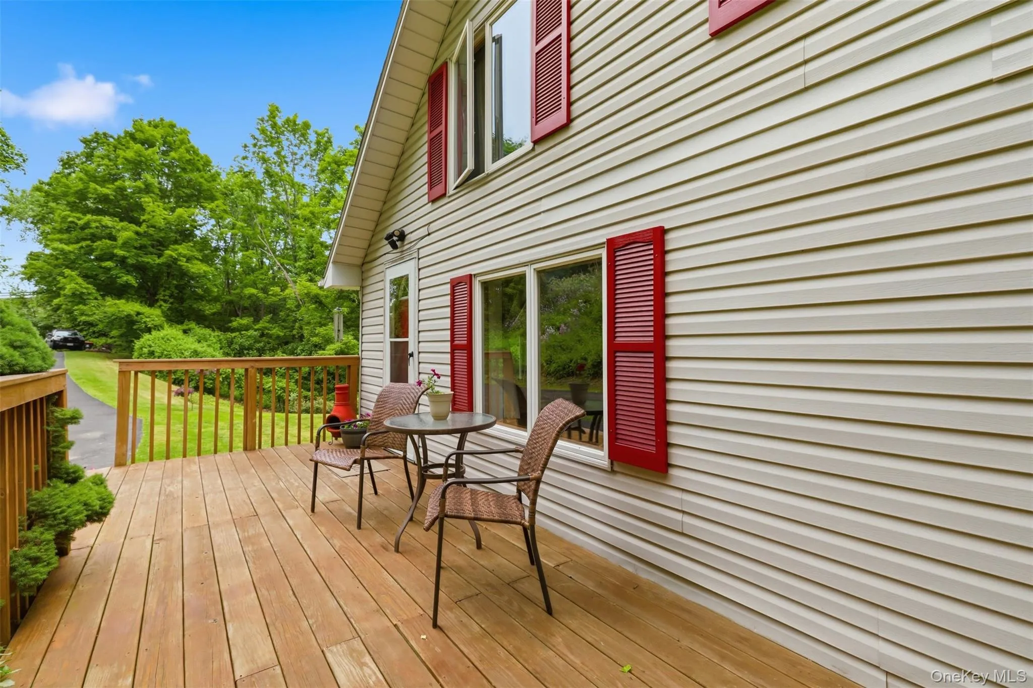Double-sided wood-finish deck with a wood railing system, offering outdoor living space Double-sided wood-finish deck with a wood railing system, offering outdoor living space