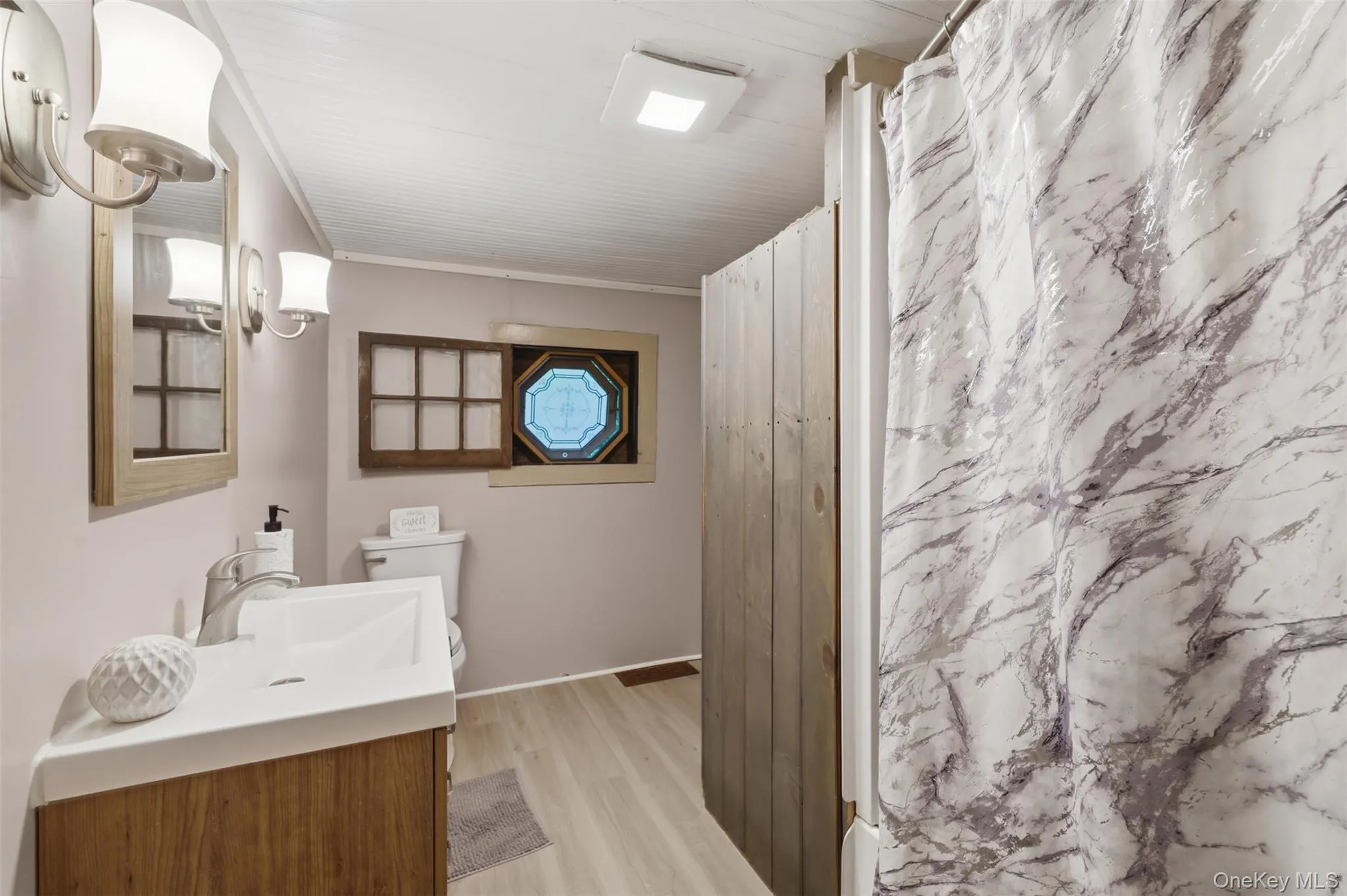 1st floor full bathroom featuring a wood-finish vanity and original stained glass window 1st floor full bathroom featuring a wood-finish vanity and original stained glass window