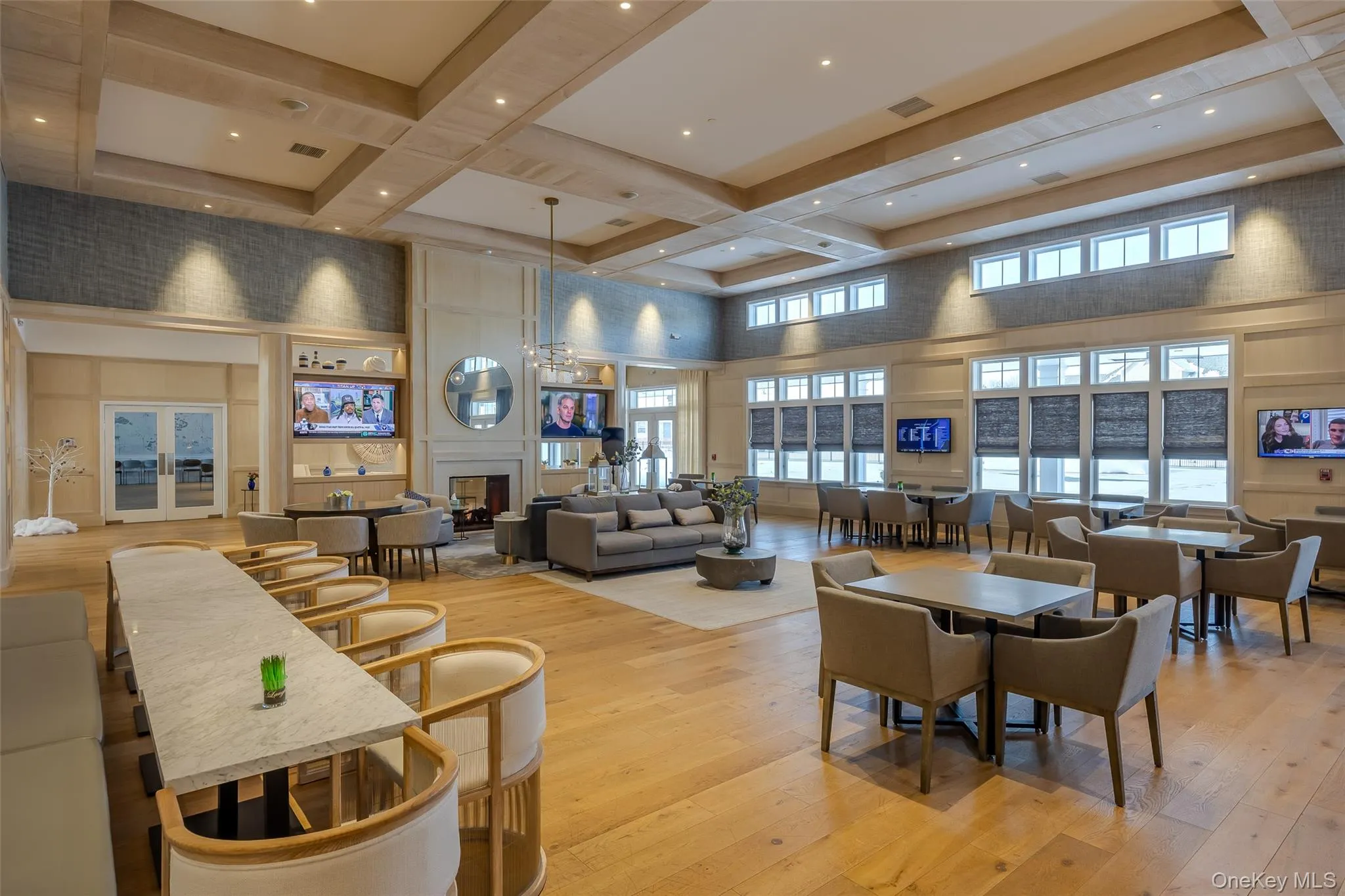 Dining room with a high ceiling, a fireplace, coffered ceiling, light wood-style flooring, and beamed ceiling Dining room with a high ceiling, a fireplace, coffered ceiling, light wood-style flooring, and beamed ceiling