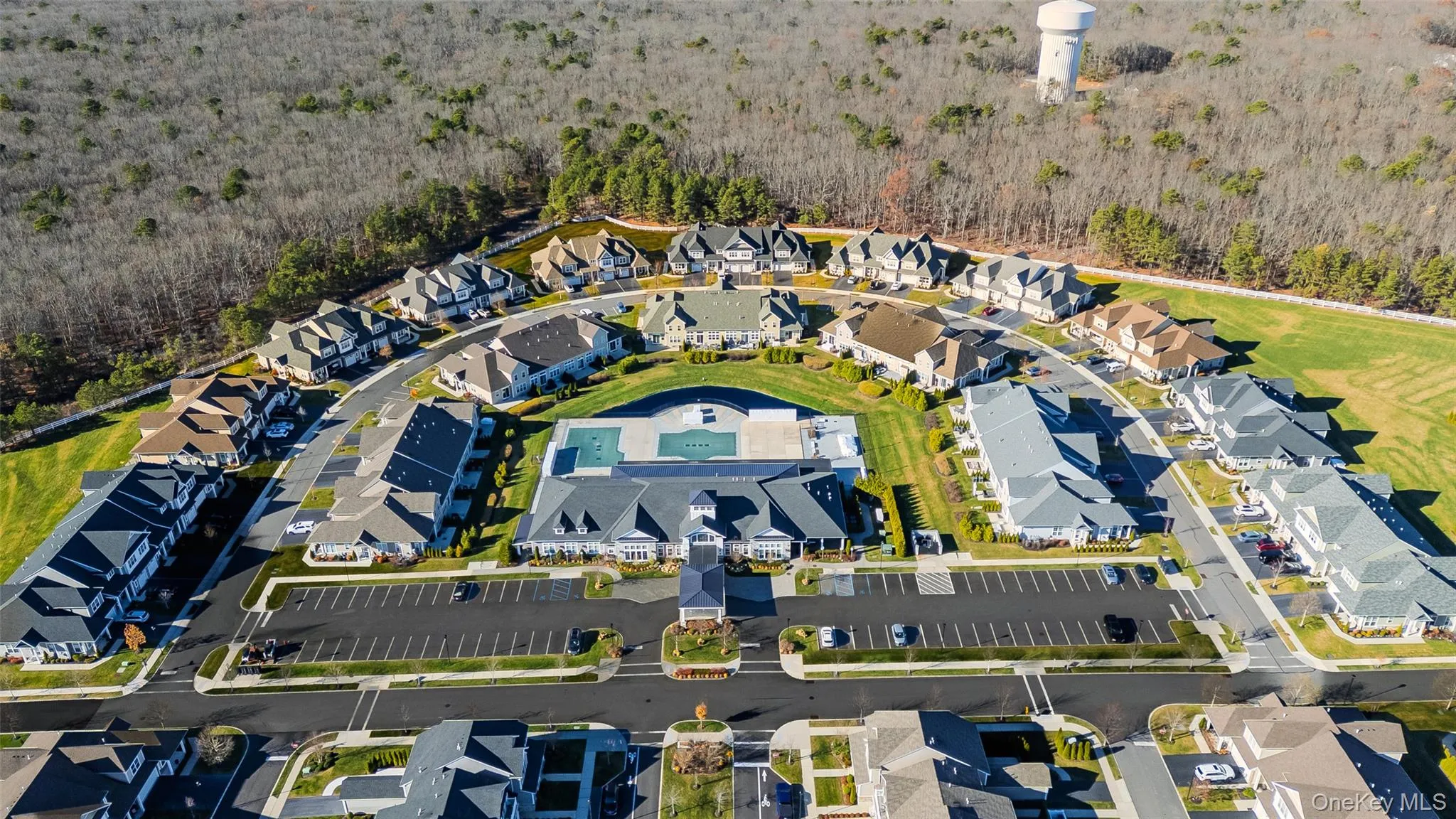 Aerial view of property and surrounding area featuring a heavily wooded area and nearby suburban area Aerial view of property and surrounding area featuring a heavily wooded area and nearby suburban area