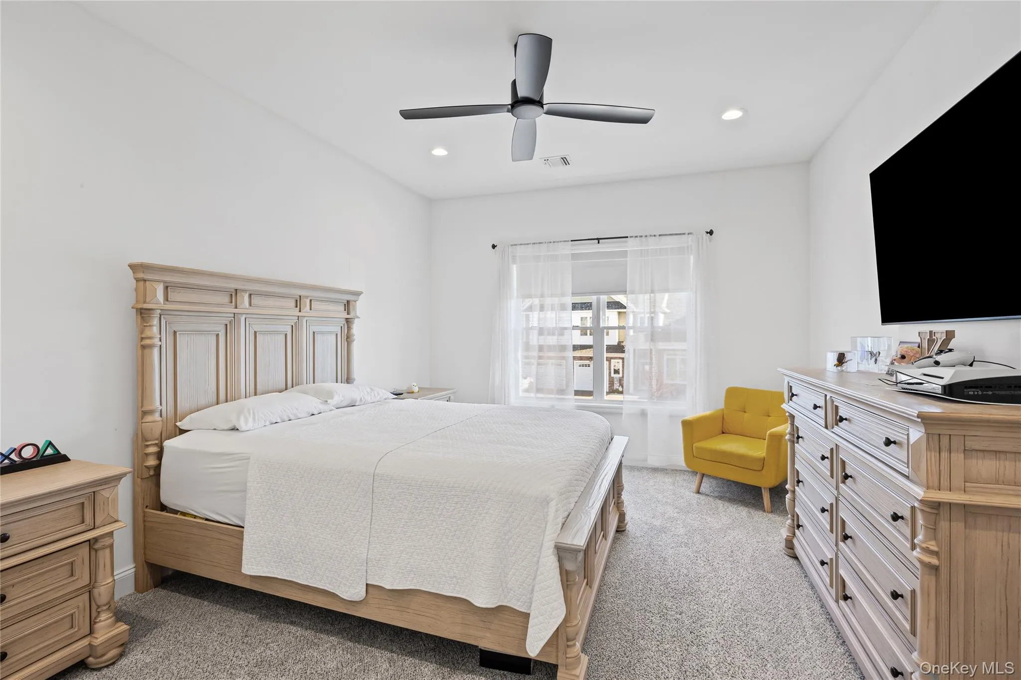 Bedroom featuring light colored carpet, a ceiling fan, and recessed lighting Bedroom featuring light colored carpet, a ceiling fan, and recessed lighting