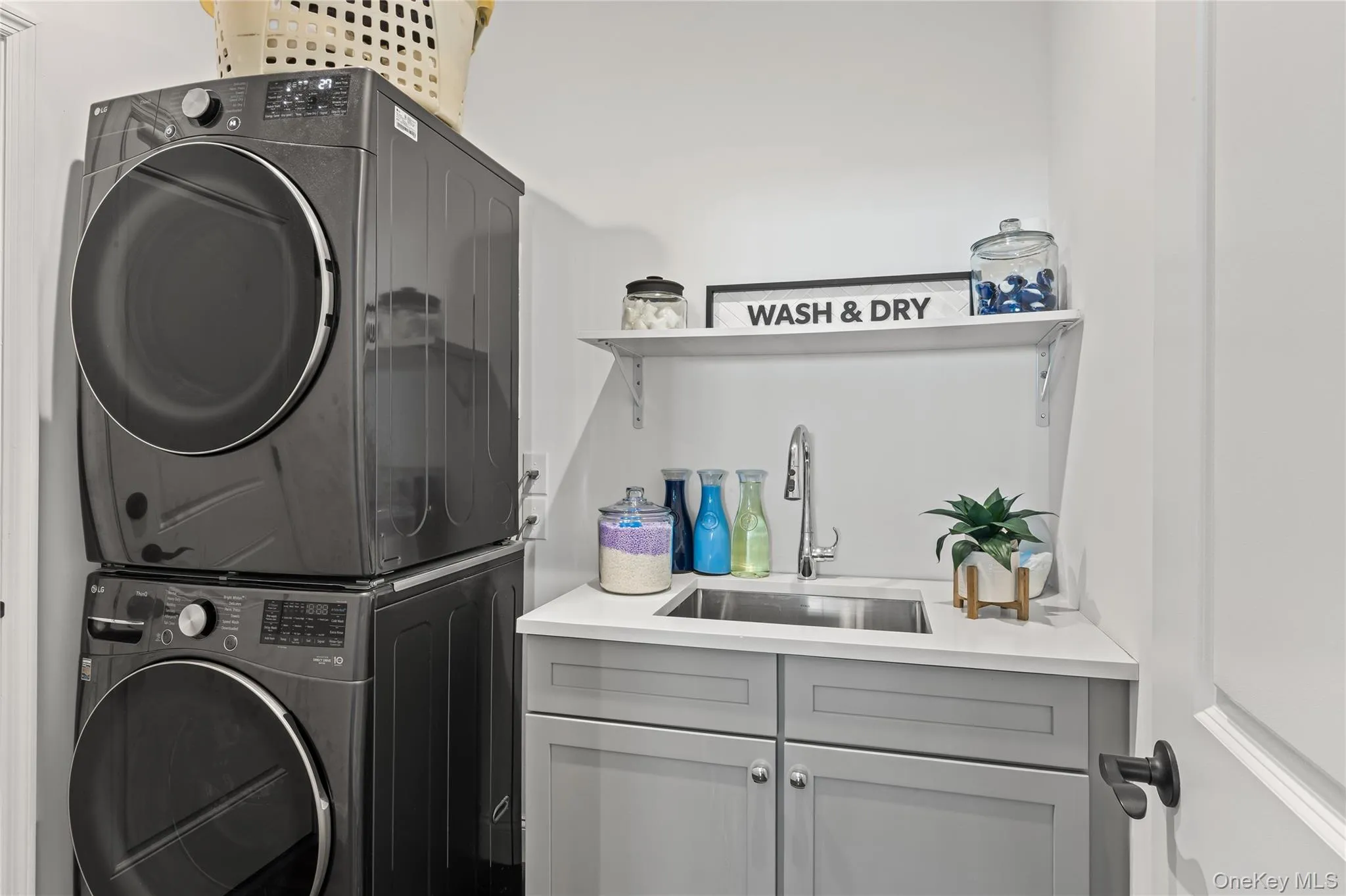 Laundry room featuring cabinet space and stacked washer / drying machine Laundry room featuring cabinet space and stacked washer / drying machine