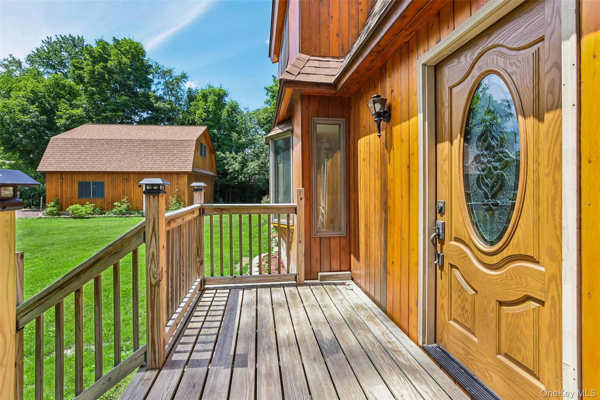 Front door and front deck with garage in background Front door and front deck with garage in background