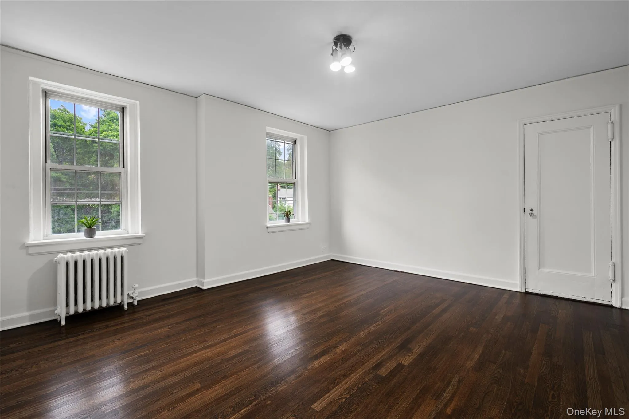 The spacious, bright bedroom showcases hardwood floors while offering the added benefit of a nearby emergency exit for security and convenience The spacious, bright bedroom showcases hardwood floors while offering the added benefit of a nearby emergency exit for security and convenience