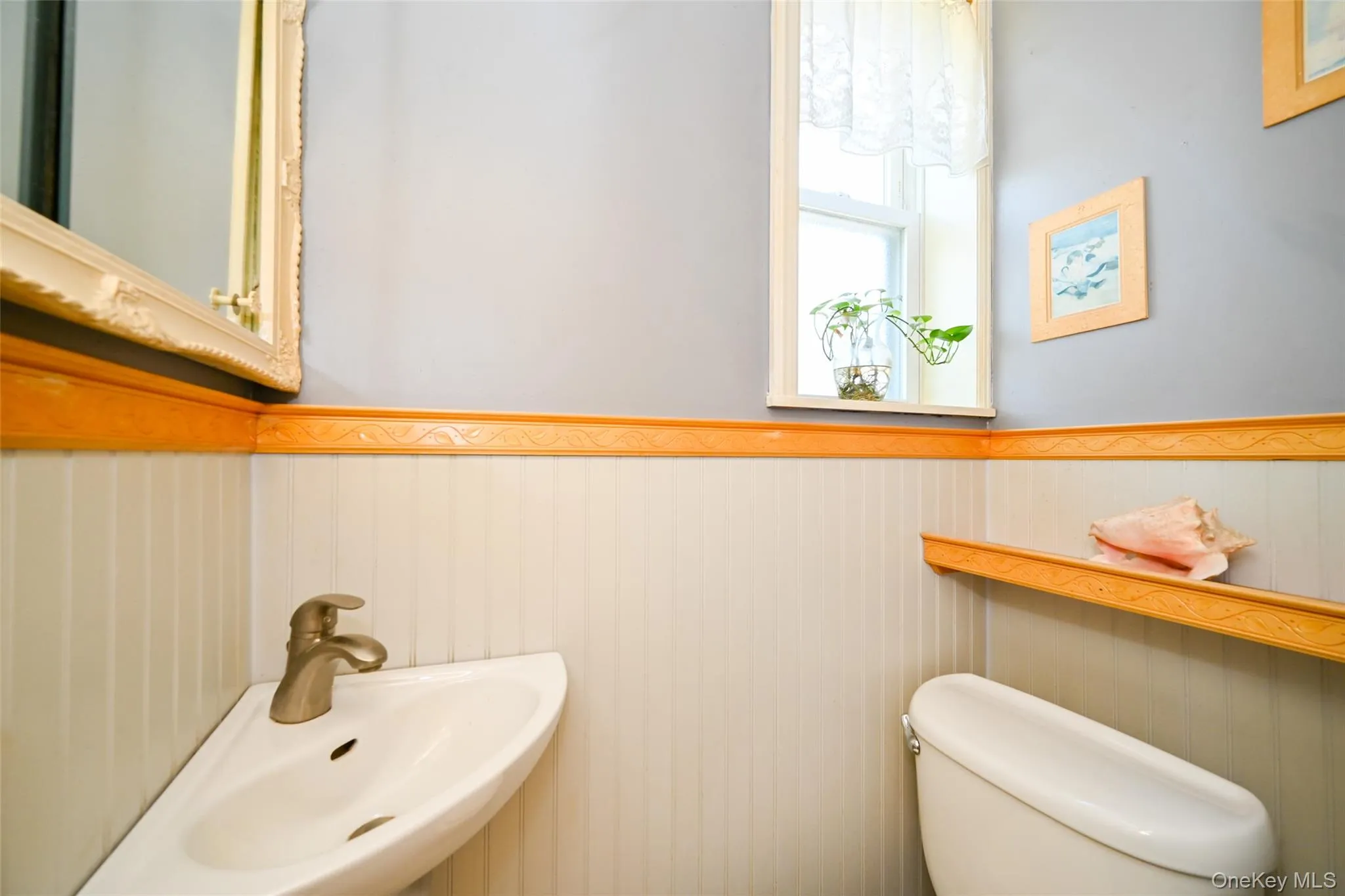 Corner-mounted sink with brushed nickel faucet, light wood trim, and a functional window. Corner-mounted sink with brushed nickel faucet, light wood trim, and a functional window.
