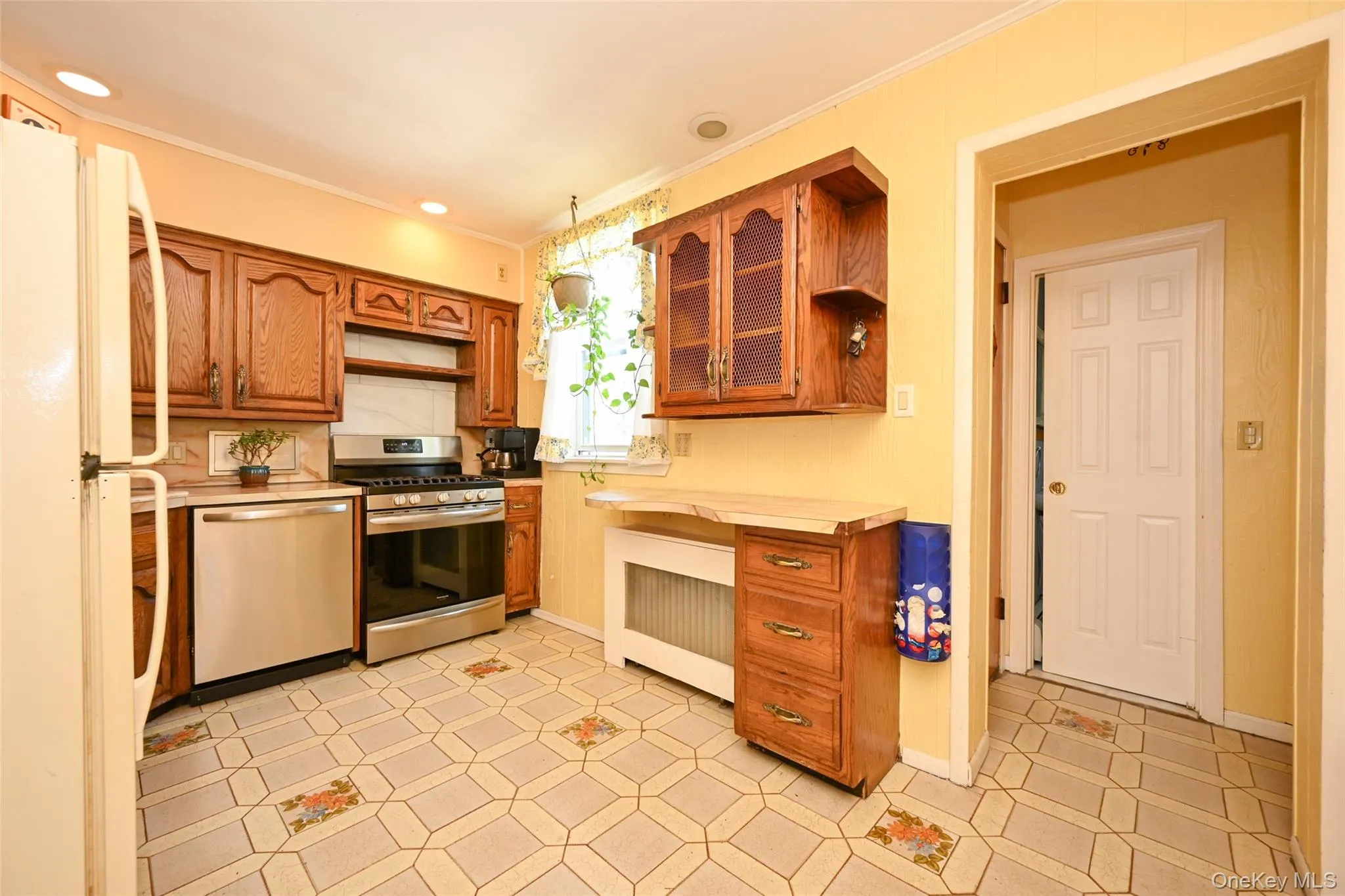Kitchen featuring wood cabinetry, patterned flooring, recessed lighting. Kitchen featuring wood cabinetry, patterned flooring, recessed lighting.
