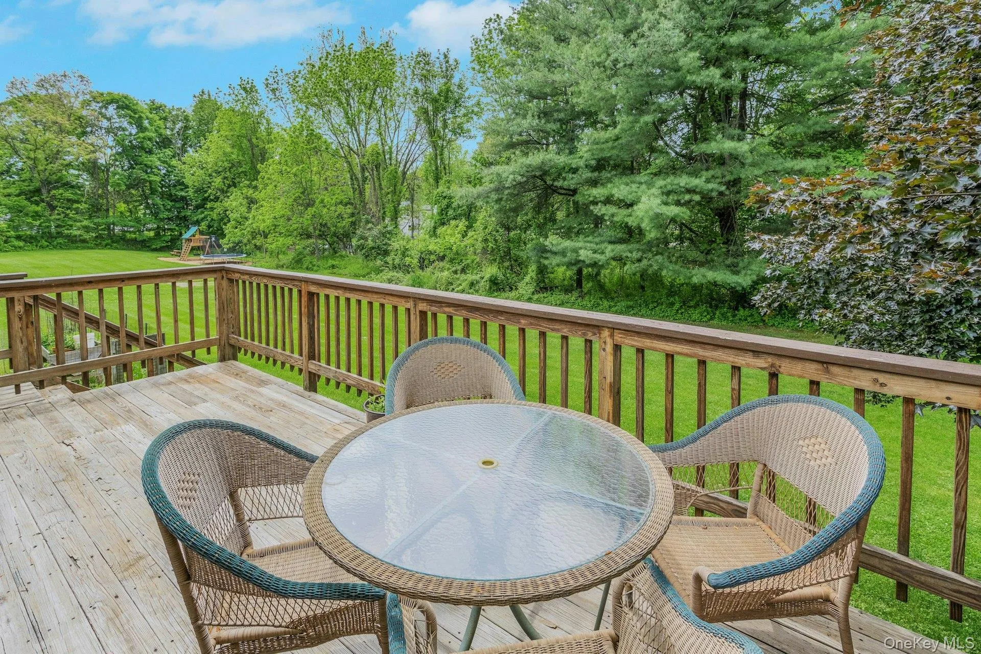 Expansive wooden deck with railing overlooking a substantial yard. Expansive wooden deck with railing overlooking a substantial yard.