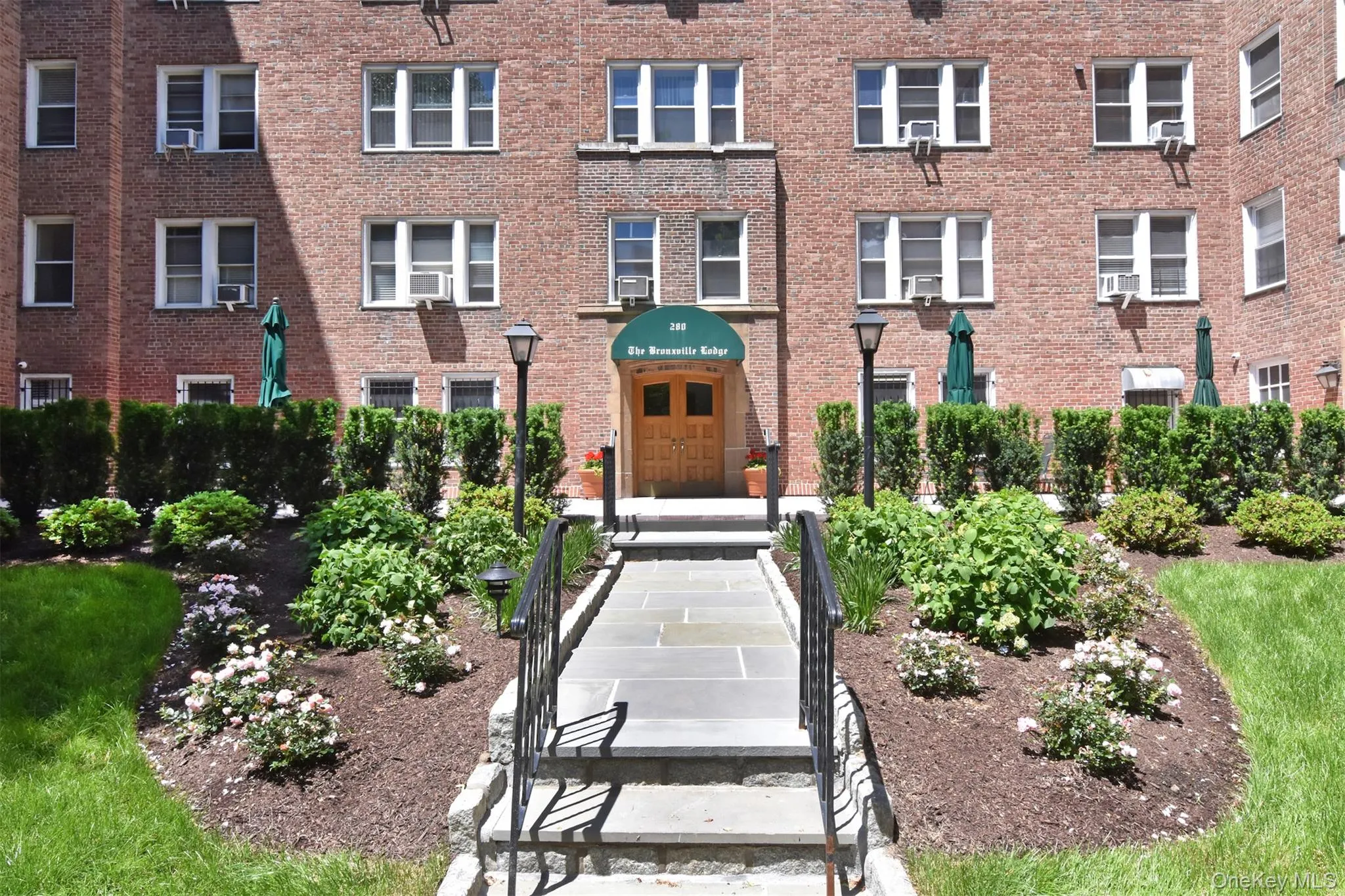 At the rear of the building, a secondary entrance opens to a beautifully landscaped courtyard and well-maintained grounds. At the rear of the building, a secondary entrance opens to a beautifully landscaped courtyard and well-maintained grounds.