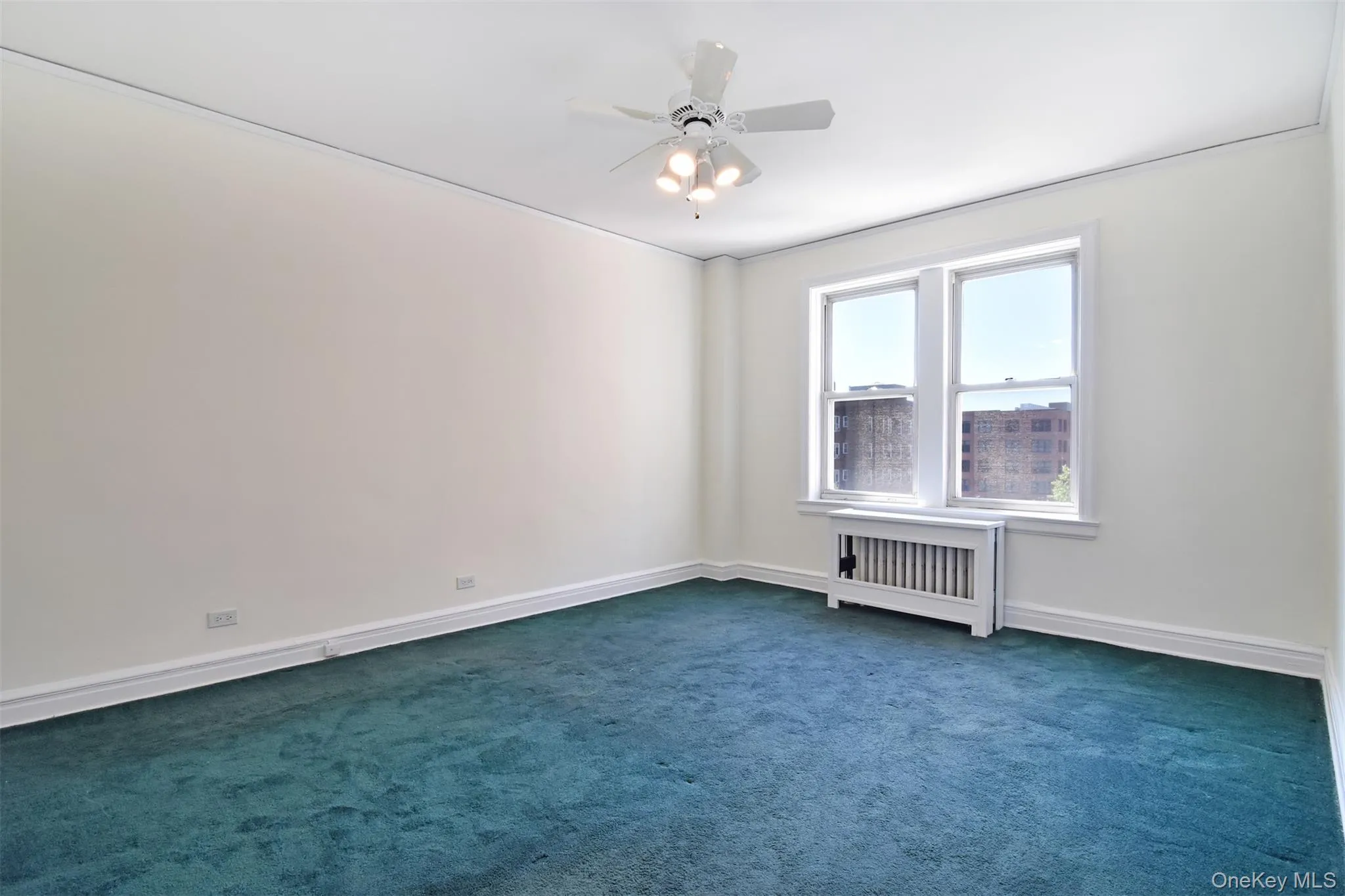 A generously sized bedroom is currently carpeted, with hardwood flooring preserved underneath. A generously sized bedroom is currently carpeted, with hardwood flooring preserved underneath.