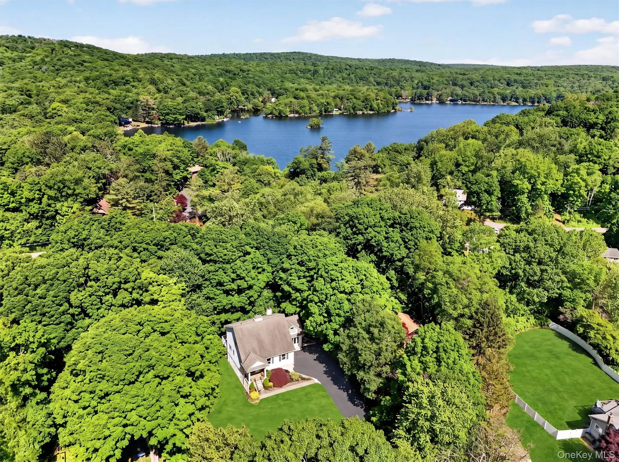 Spectacular Aerial view showcasing the home's beautiful setting & nearby lake. Spectacular Aerial view showcasing the home's beautiful setting & nearby lake.