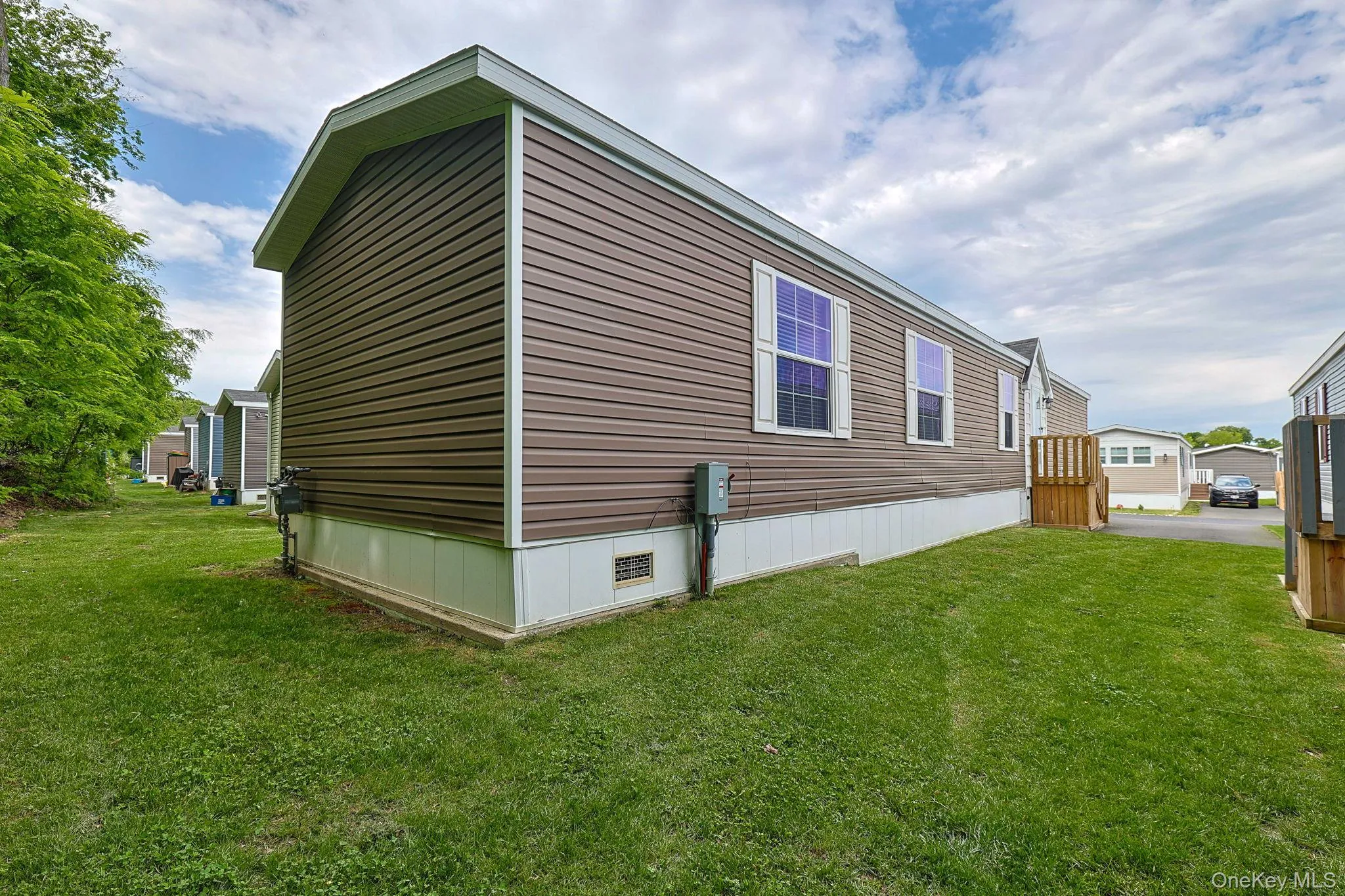 Exterior featuring brown horizontal siding, white trim, and white window shutters Exterior featuring brown horizontal siding, white trim, and white window shutters