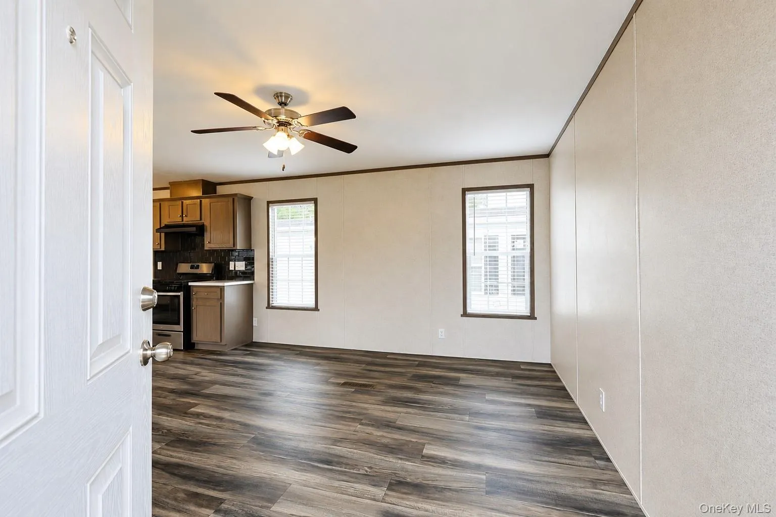 Spacious interior featuring wood-finish flooring, light-toned walls, and dark trim Spacious interior featuring wood-finish flooring, light-toned walls, and dark trim
