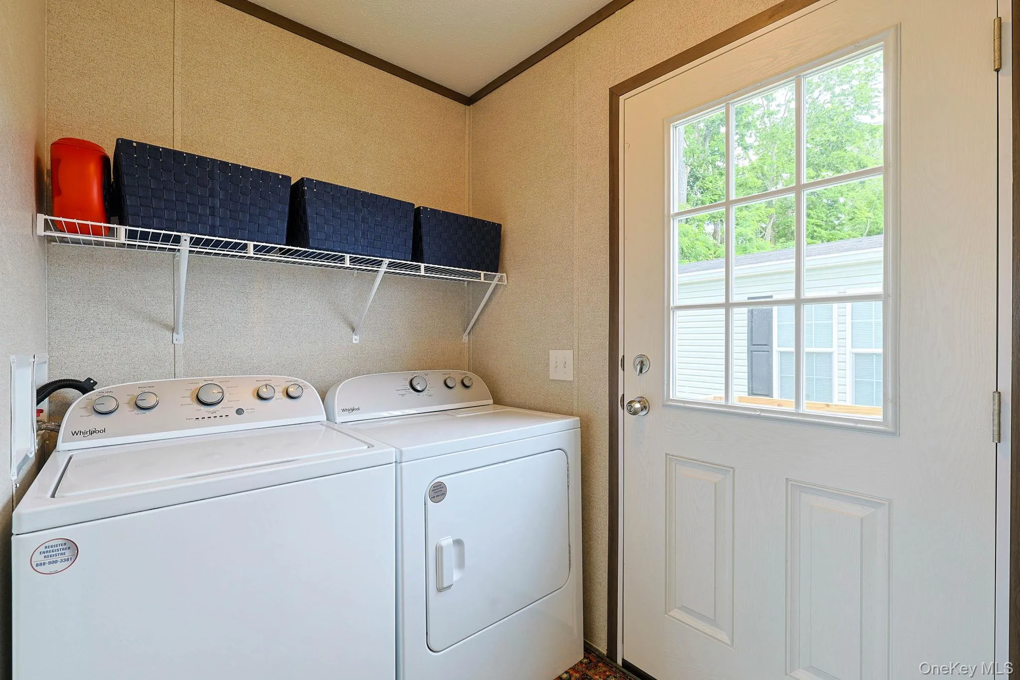 Dedicated laundry area featuring a white wire shelving unit and a panel-style exterior door with gridded glass Dedicated laundry area featuring a white wire shelving unit and a panel-style exterior door with gridded glass