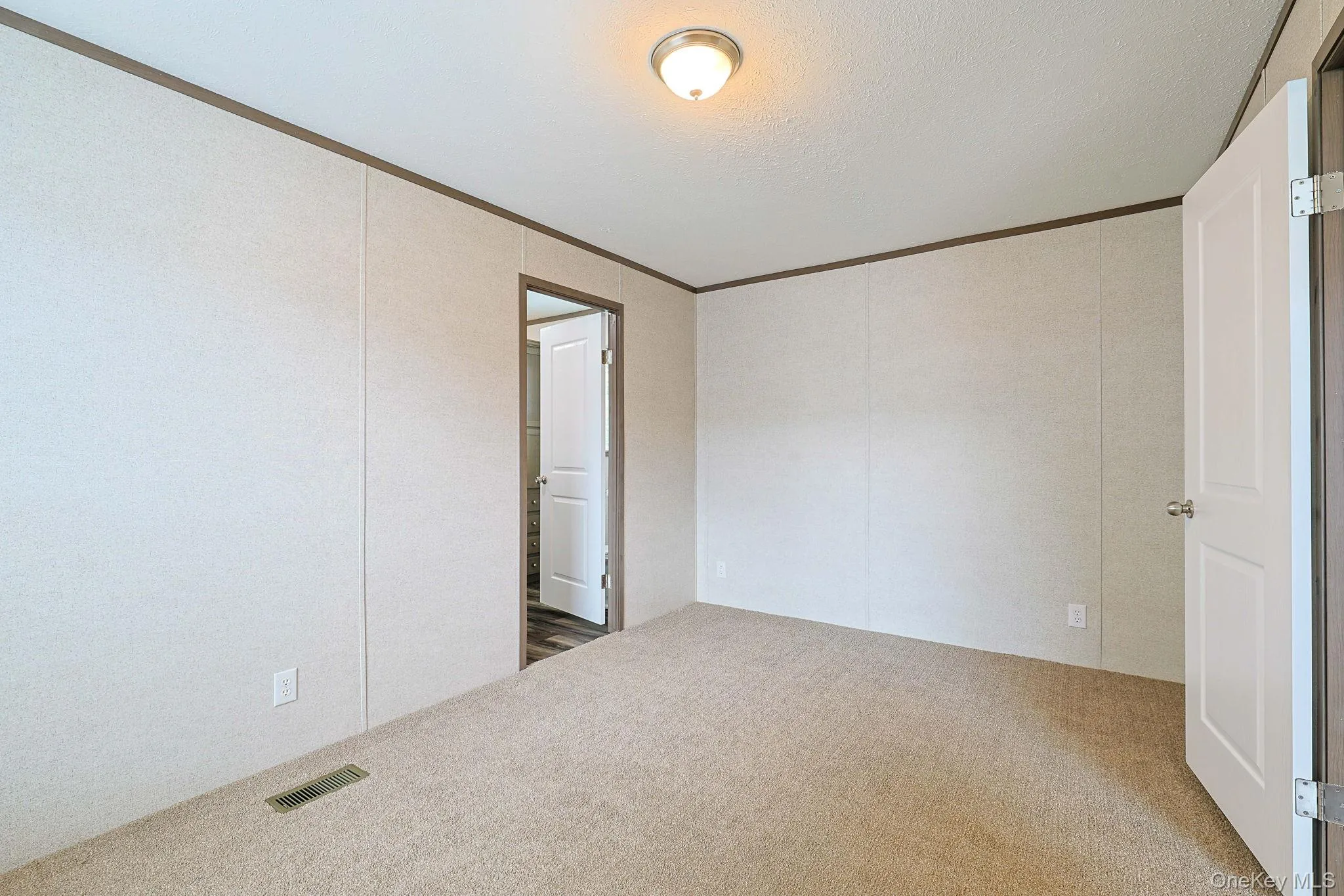 Spacious interior featuring wood-finish flooring, light-toned walls, and dark trim Spacious interior featuring wood-finish flooring, light-toned walls, and dark trim