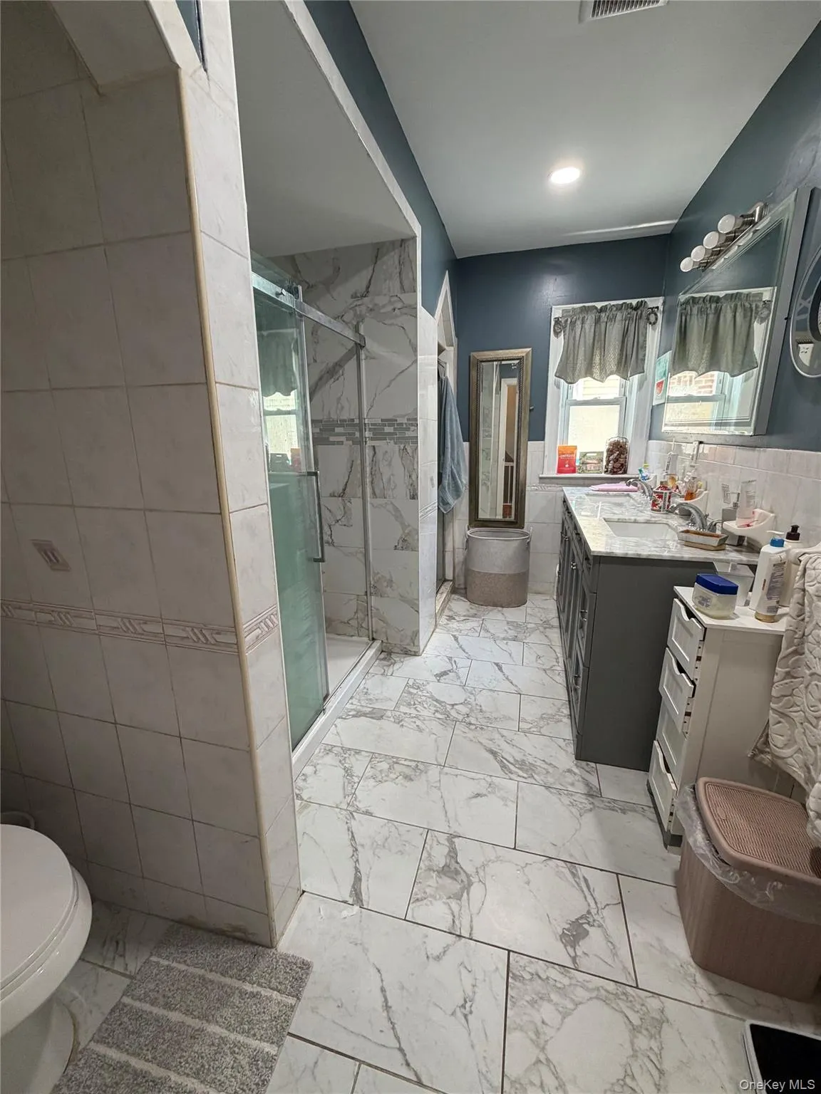 Bathroom featuring marble-look floor and shower wall tiling Bathroom featuring marble-look floor and shower wall tiling