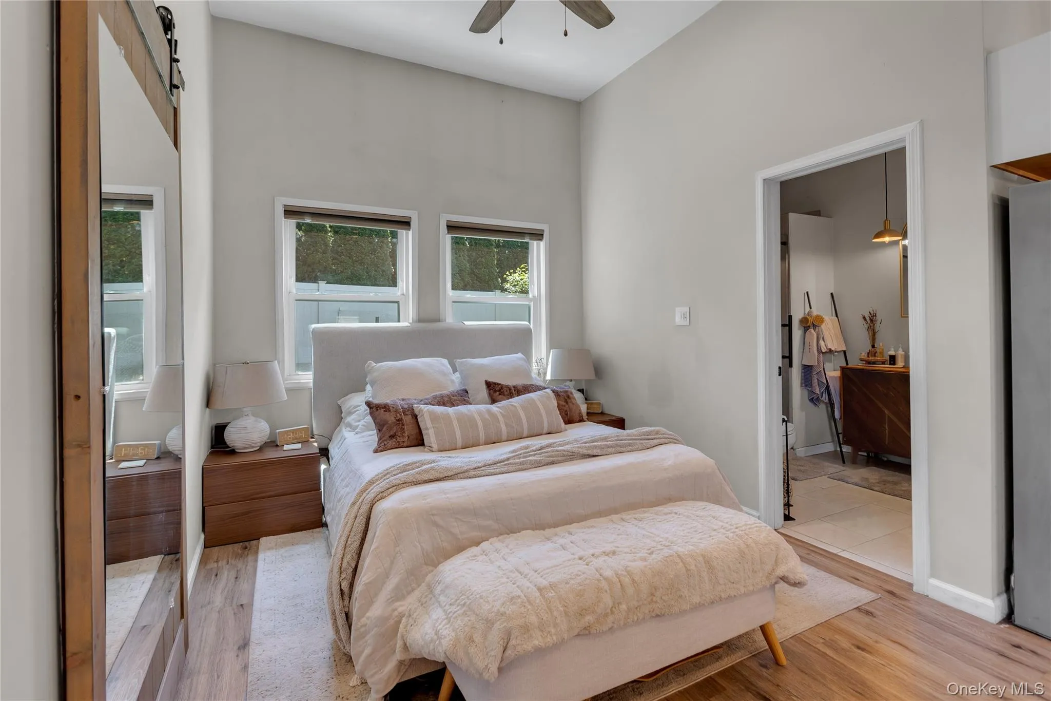 Vaulted ceiling bedroom featuring wood-finish flooring and two upper windows Vaulted ceiling bedroom featuring wood-finish flooring and two upper windows