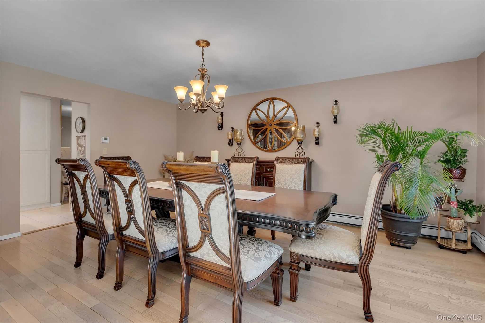 Formal dining area featuring light wood-finish flooring, a decorative chandelier, and a neutral wall color Formal dining area featuring light wood-finish flooring, a decorative chandelier, and a neutral wall color