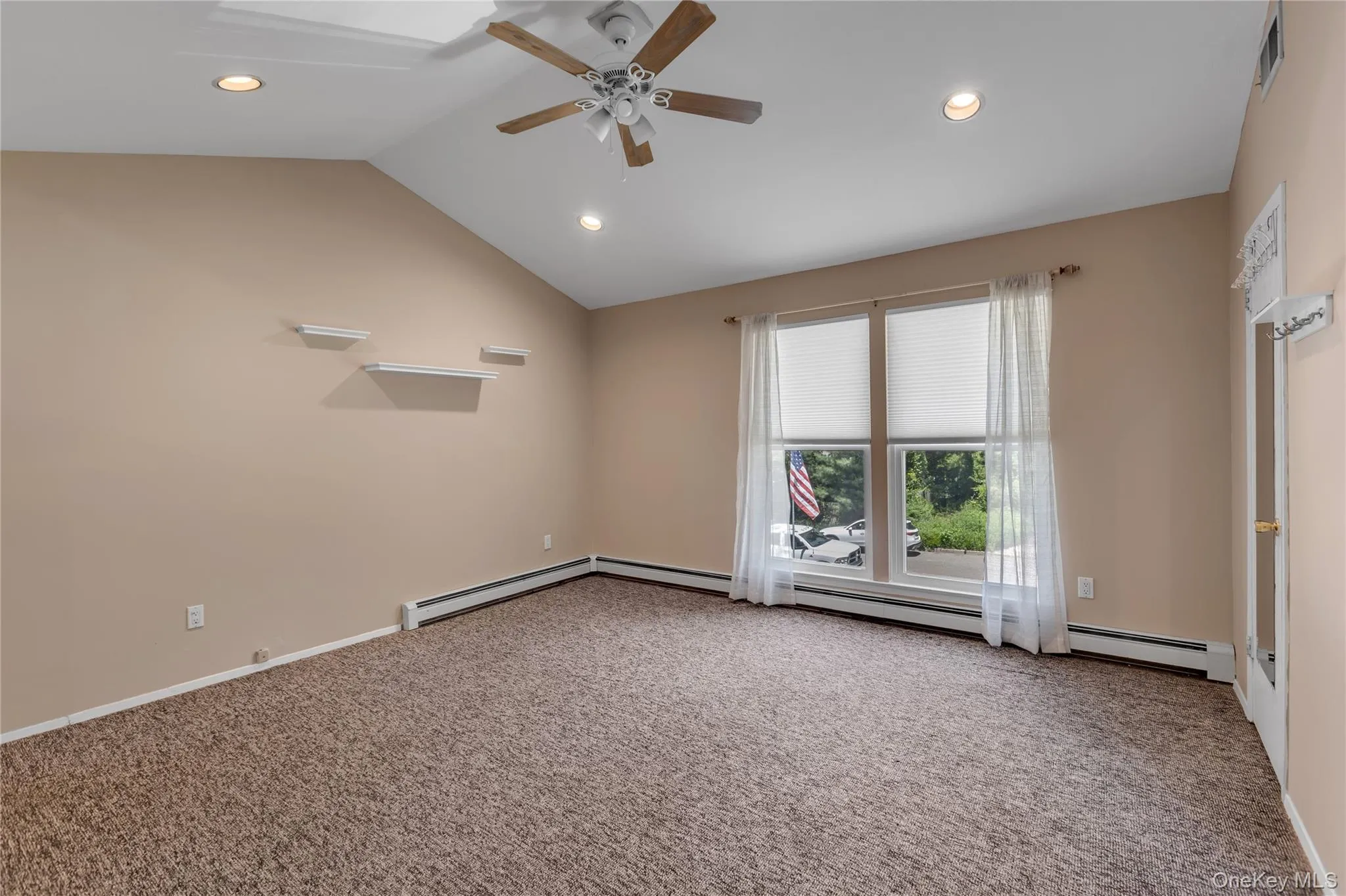 Room featuring a vaulted ceiling with a ceiling fan, recessed lighting, and expansive windows Room featuring a vaulted ceiling with a ceiling fan, recessed lighting, and expansive windows