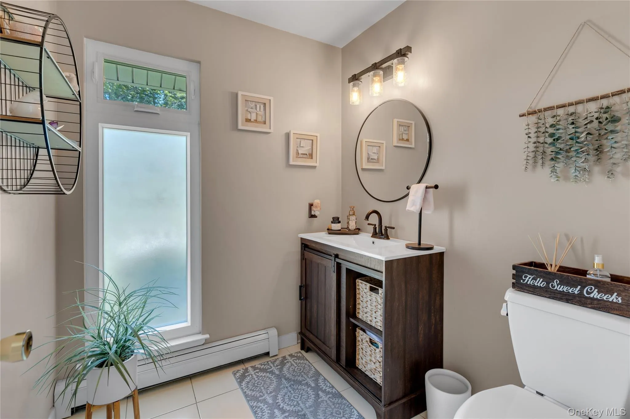 Contemporary vanity with a rectangular basin sink, dark finish cabinetry, and circular mirror Contemporary vanity with a rectangular basin sink, dark finish cabinetry, and circular mirror