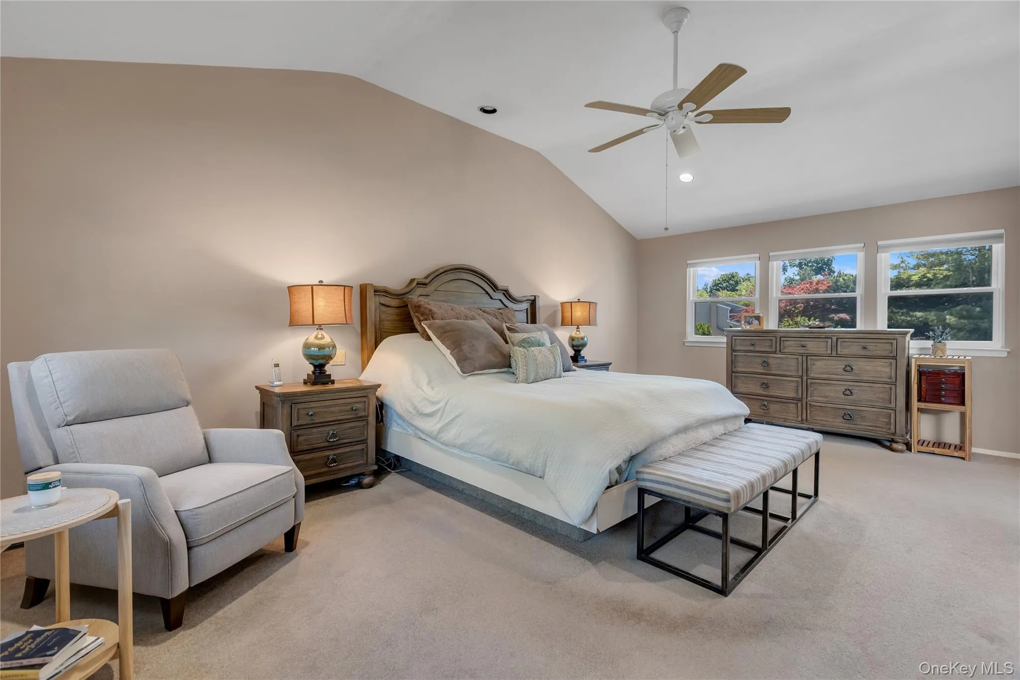 Vaulted ceiling bedroom with a ceiling fan, recessed lighting, and three windows offering natural light Vaulted ceiling bedroom with a ceiling fan, recessed lighting, and three windows offering natural light