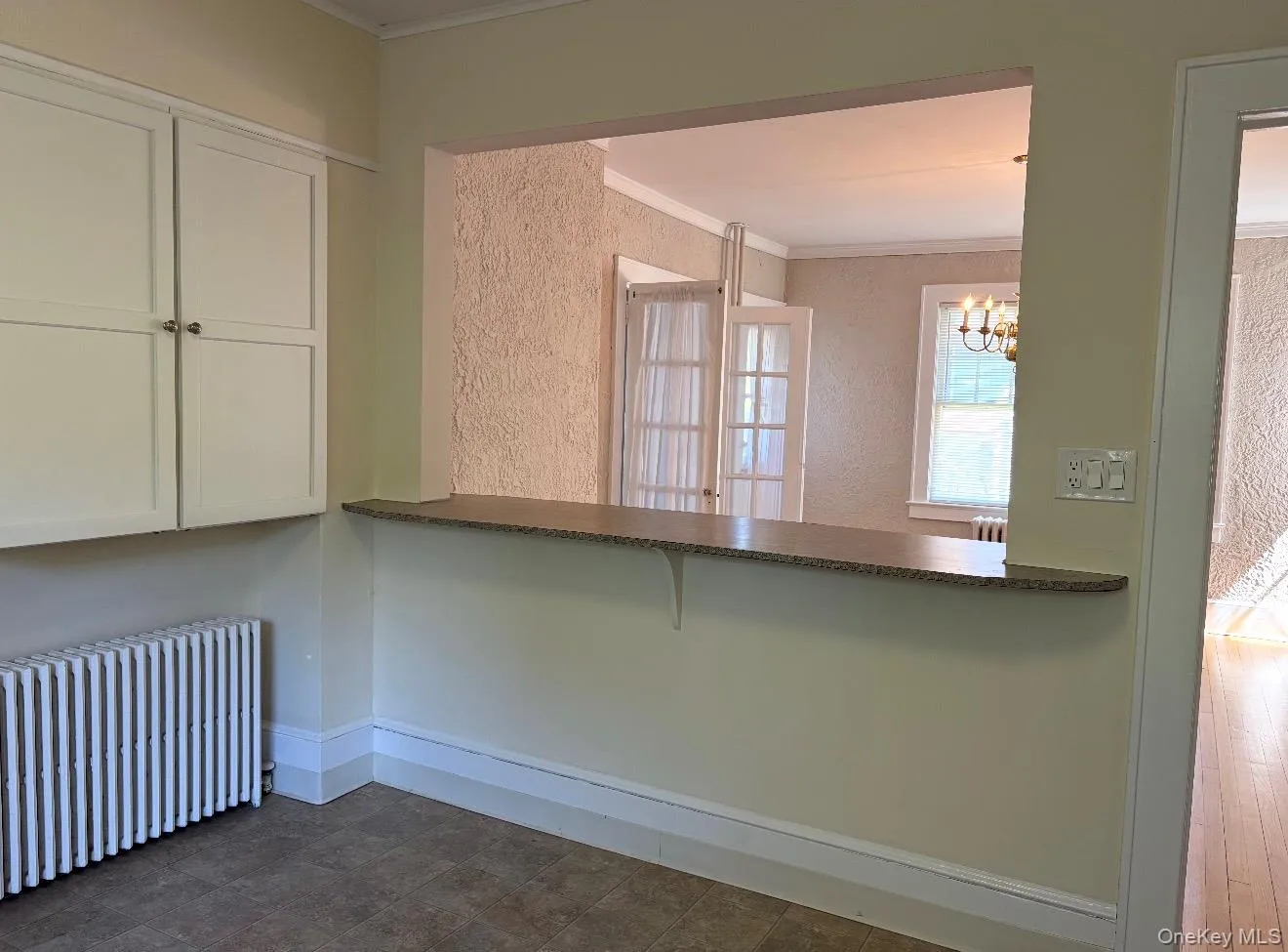Built-in pass-through with a countertop, light-toned cabinetry, and tile-finish flooring Built-in pass-through with a countertop, light-toned cabinetry, and tile-finish flooring
