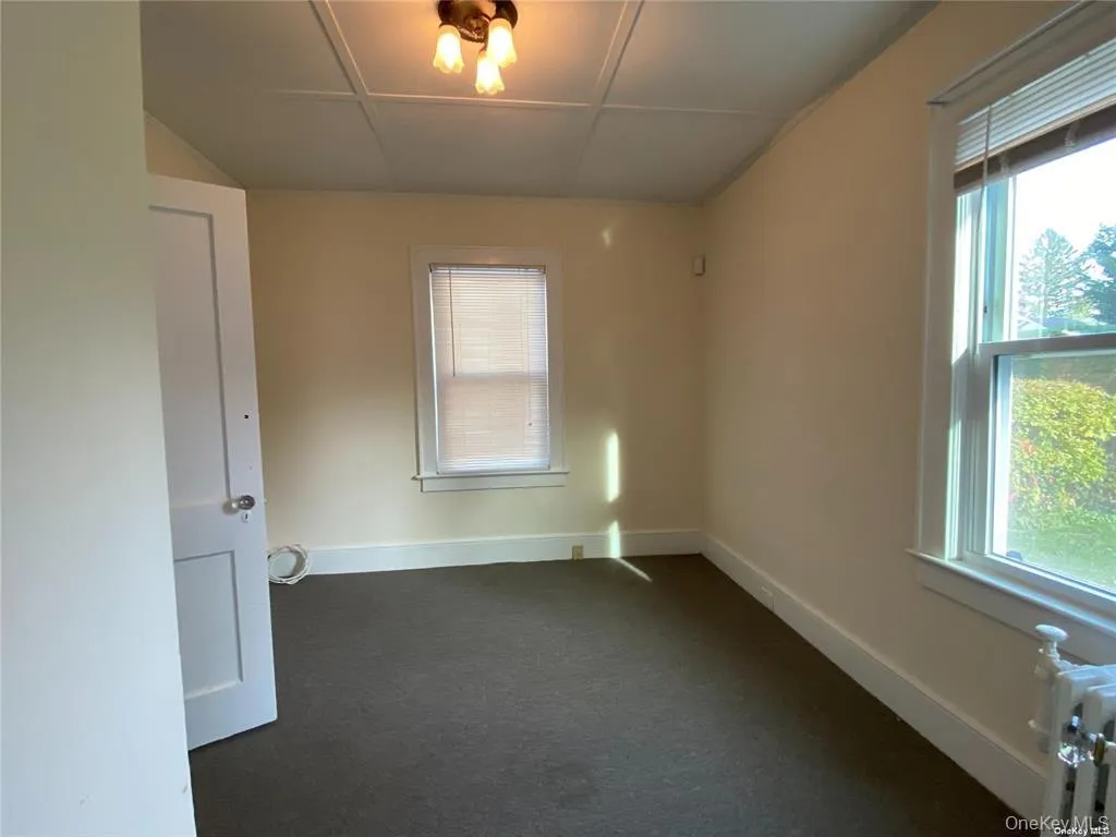 Wall-to-wall carpeting, classic white trim, and a prominent window Wall-to-wall carpeting, classic white trim, and a prominent window