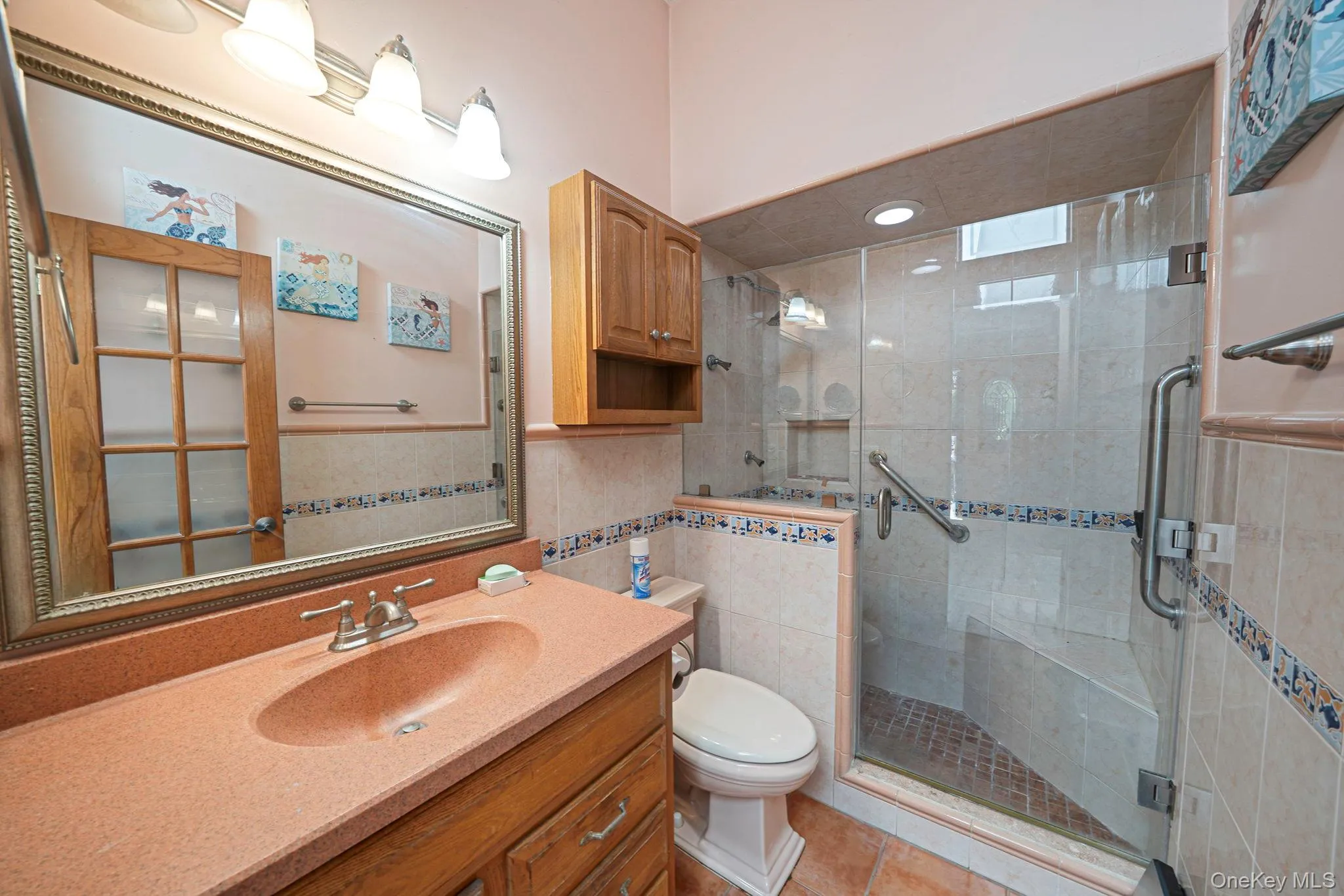Full bathroom with spacious tiled shower and glass shower doors. Full bathroom with spacious tiled shower and glass shower doors.