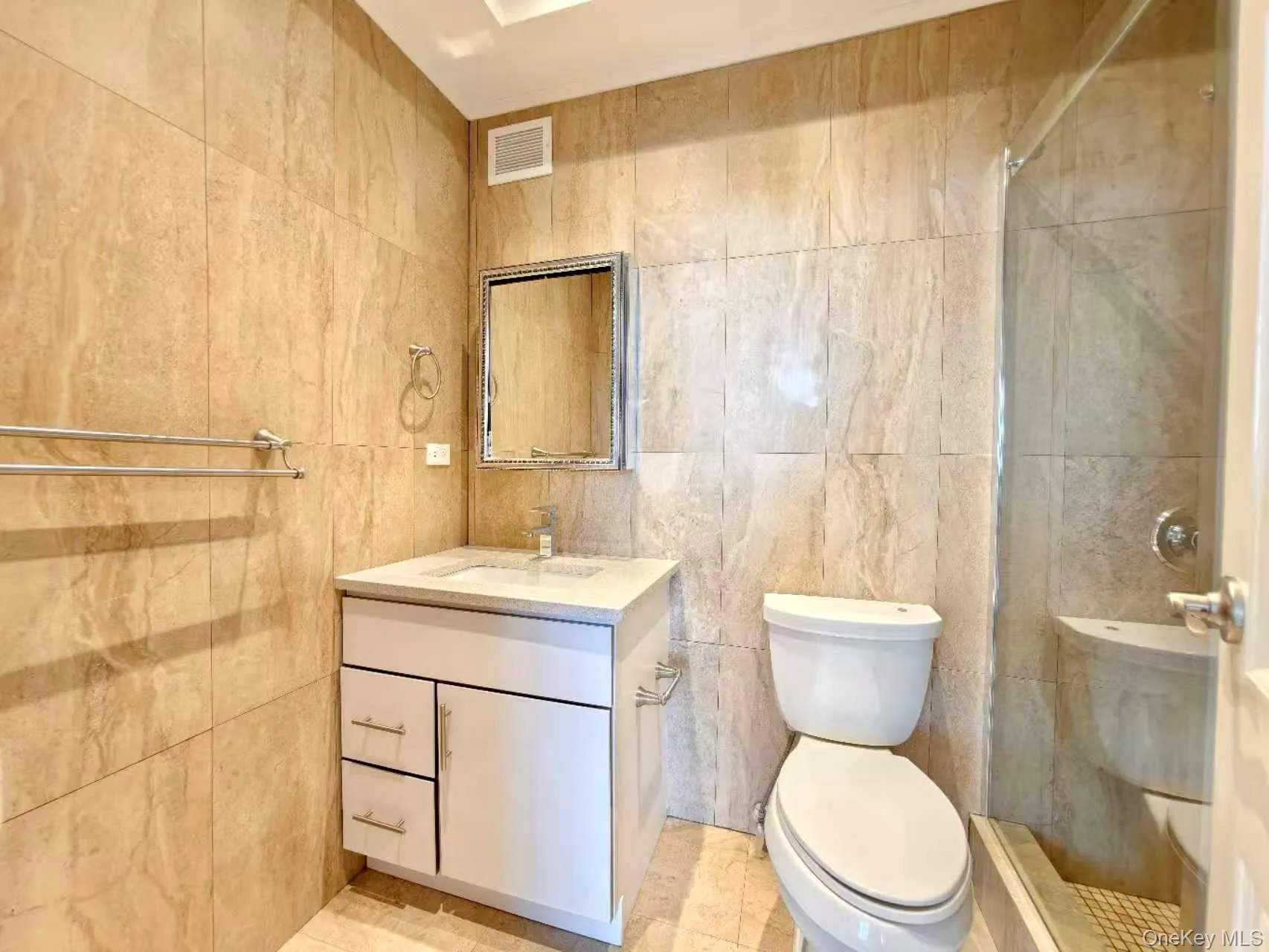 Bathroom with tile walls, vanity, and a tile shower Bathroom with tile walls, vanity, and a tile shower