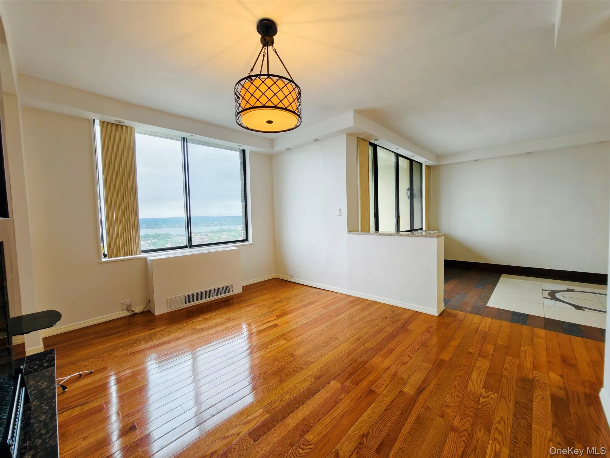 Unfurnished living room featuring hardwood / wood-style flooring and radiator Unfurnished living room featuring hardwood / wood-style flooring and radiator