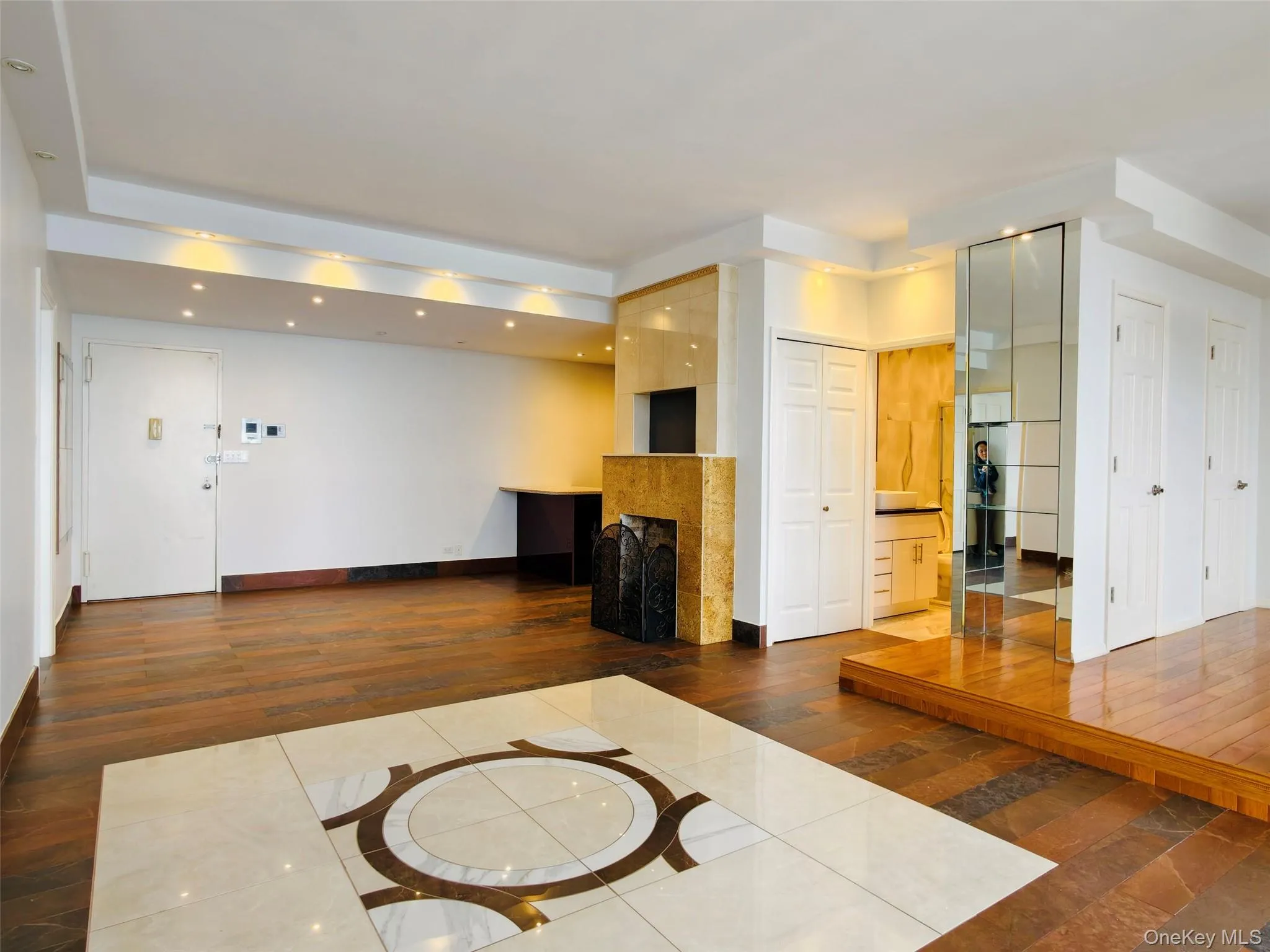 Unfurnished living room featuring a multi sided fireplace, hardwood / wood-style flooring, recessed lighting, and inlaid floor details Unfurnished living room featuring a multi sided fireplace, hardwood / wood-style flooring, recessed lighting, and inlaid floor details