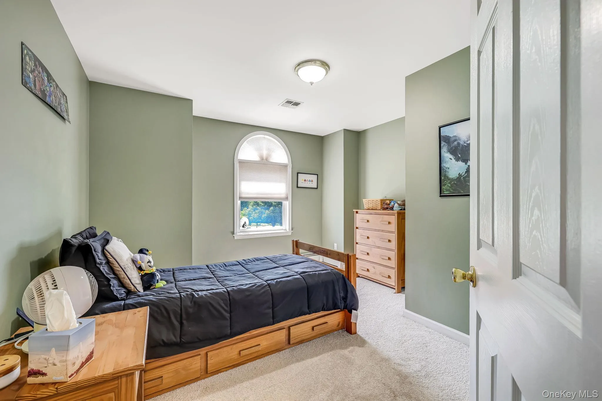 The bedroom shown here has a prominent arched window and light-colored carpeting. The bedroom shown here has a prominent arched window and light-colored carpeting.