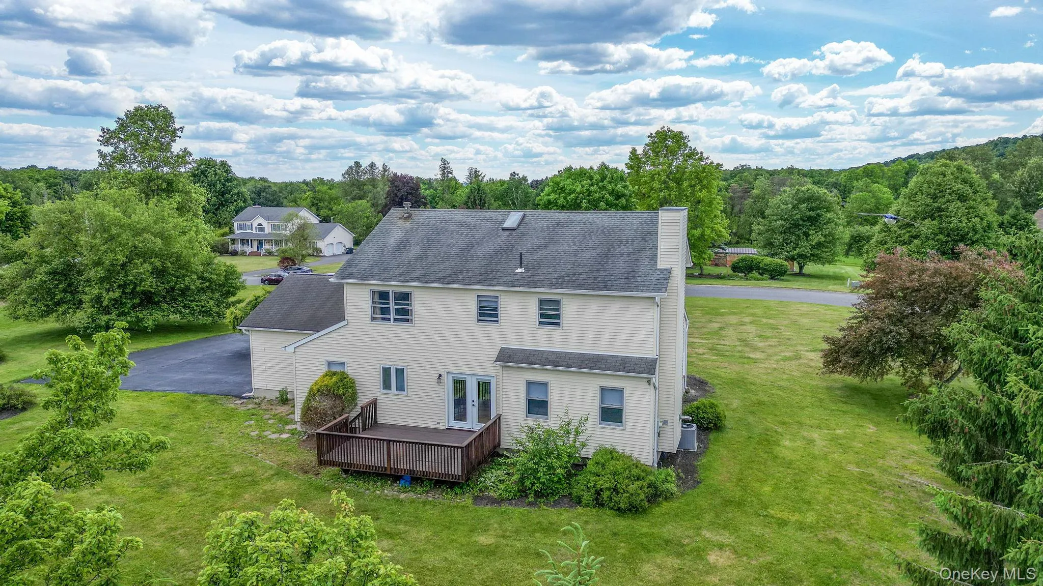 Aerial view of the exterior of the home shows the backyard deck and level yard. Aerial view of the exterior of the home shows the backyard deck and level yard.