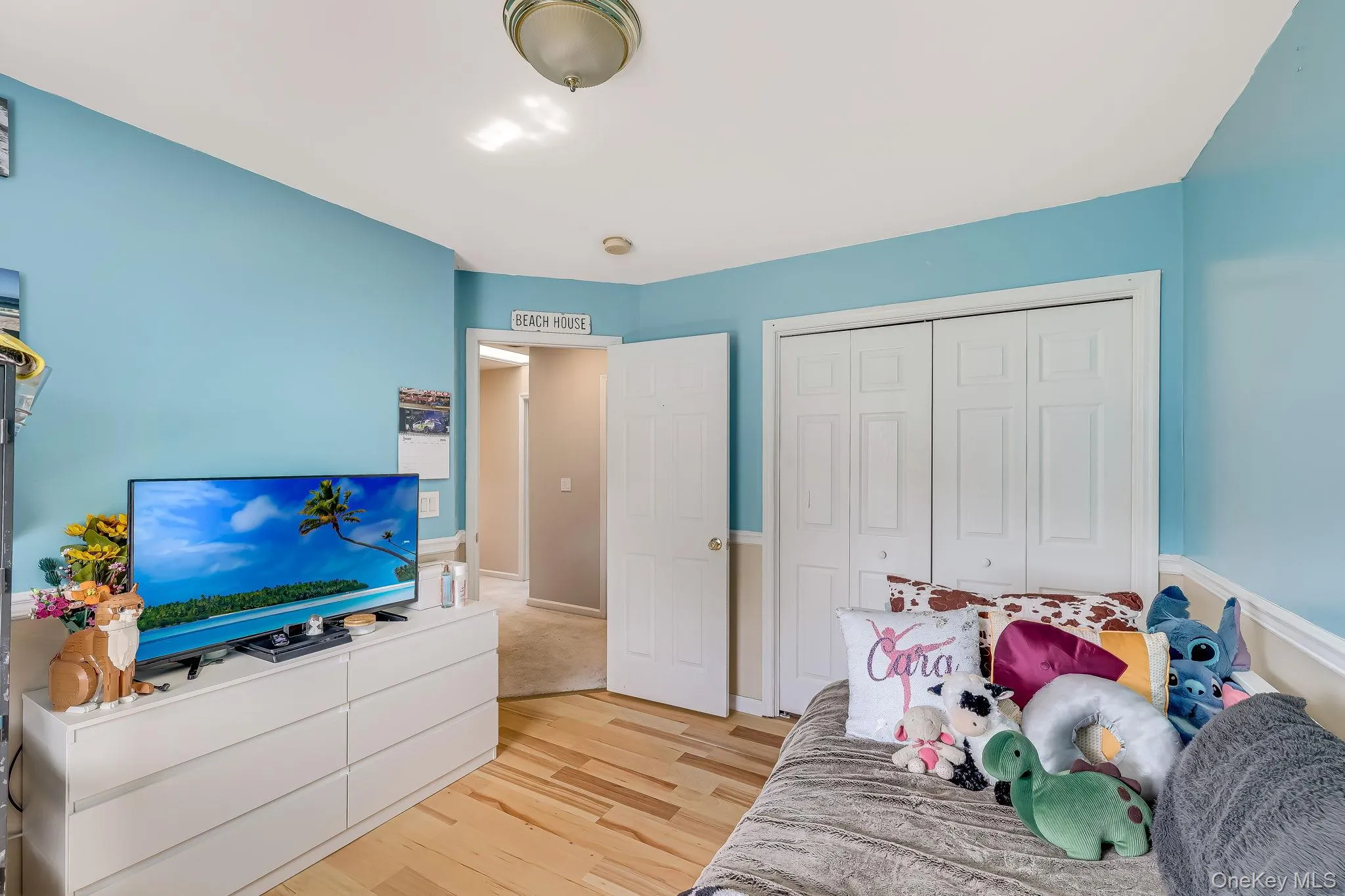 This sky blue bedroom featuring hardwood flooring and a spacious closet. This sky blue bedroom featuring hardwood flooring and a spacious closet.