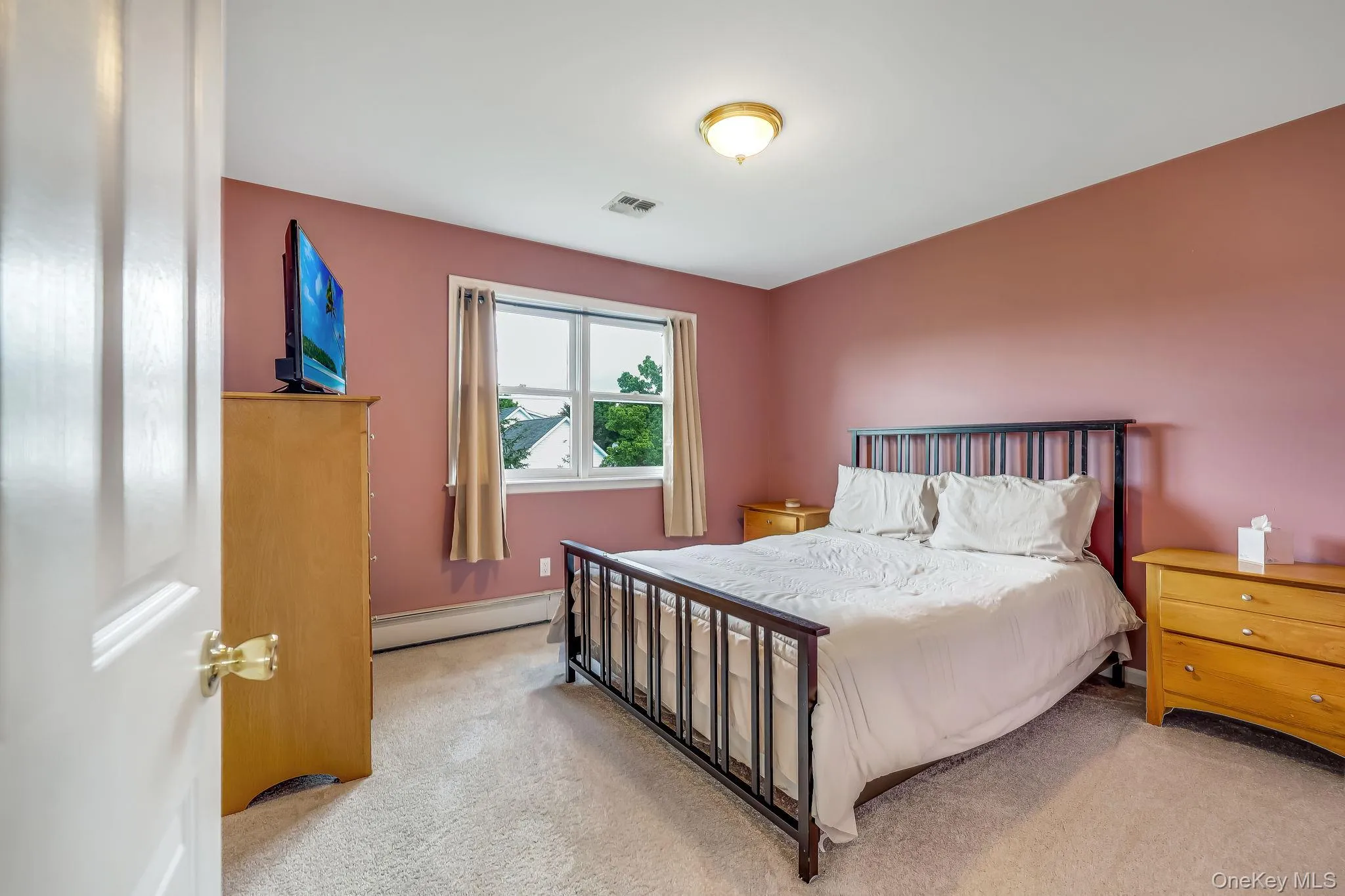 This bedroom has two windows, a ceiling-mounted light fixture, and neutral carpeting. This bedroom has two windows, a ceiling-mounted light fixture, and neutral carpeting.