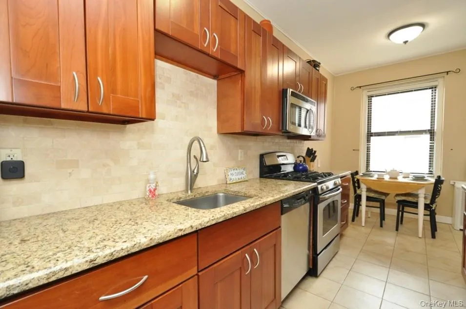 Renovated Eat-in-Kitchen has Granite Counters, Stainless Steel Appliances, Cherry Cabinets and a window for ventilation and natural light. Renovated Eat-in-Kitchen has Granite Counters, Stainless Steel Appliances, Cherry Cabinets and a window for ventilation and natural light.