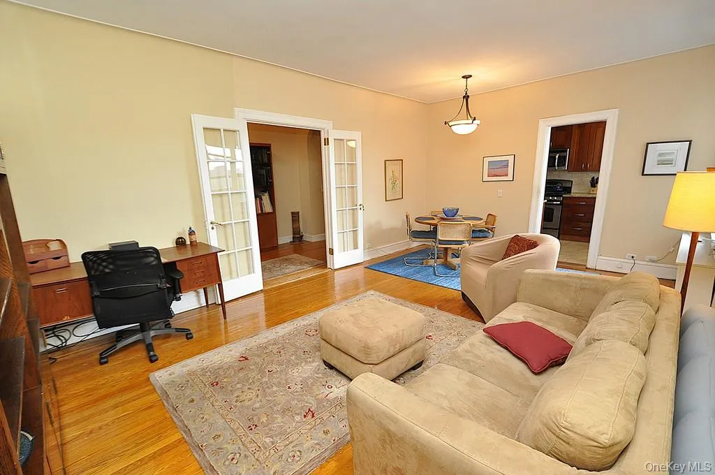 The large living room can accommodate both an entertaining and dining area. There are French doors to create privacy from the foyer. The room has hardwood floors and is approx. 12'-9" x 21'-0" The large living room can accommodate both an entertaining and dining area. There are French doors to create privacy from the foyer. The room has hardwood floors and is approx. 12'-9" x 21'-0"