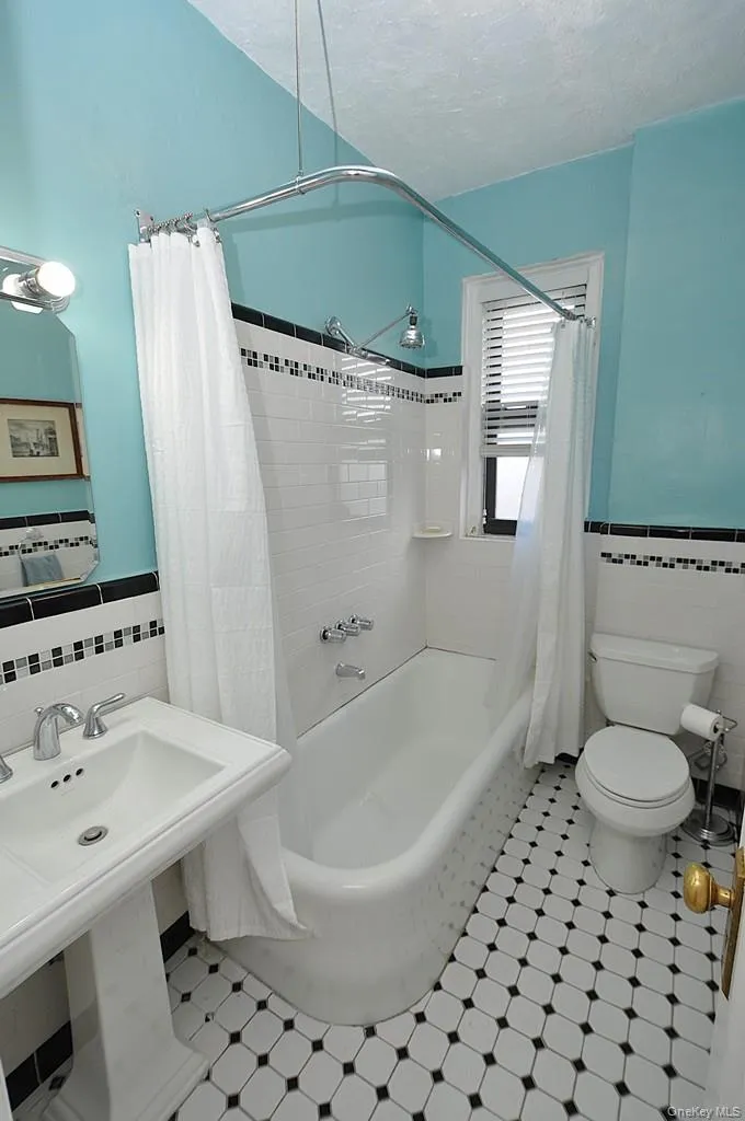 Renovated Bathroom has a pedestal sink and new floor and wall tile with a decorative trim. Renovated Bathroom has a pedestal sink and new floor and wall tile with a decorative trim.