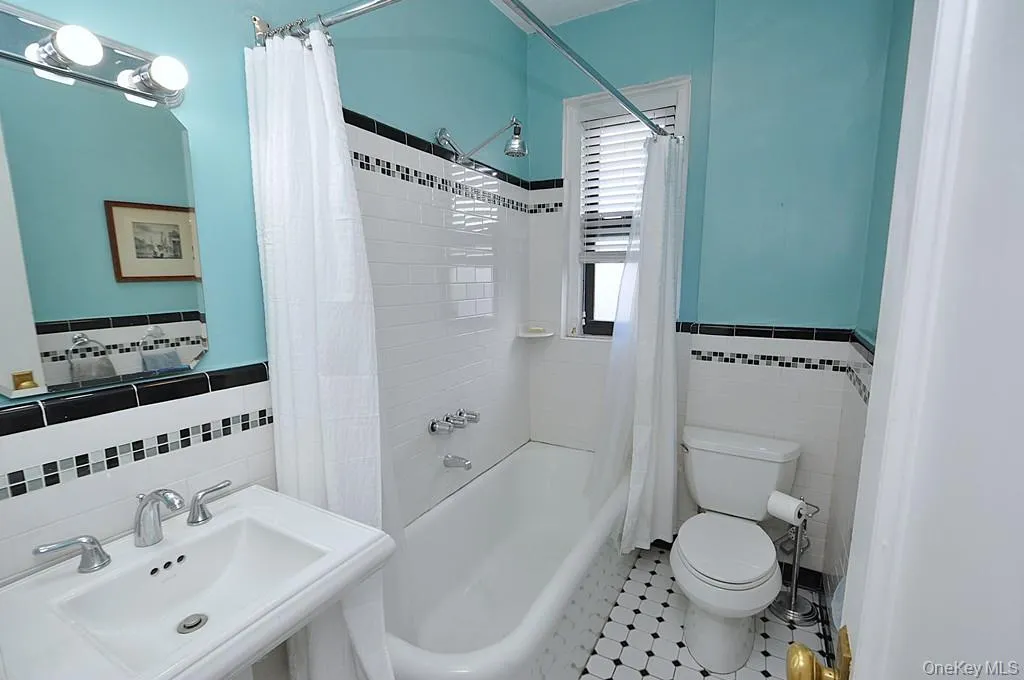 Renovated Bathroom has a pedestal sink and new floor and wall tile with a decorative trim. Renovated Bathroom has a pedestal sink and new floor and wall tile with a decorative trim.