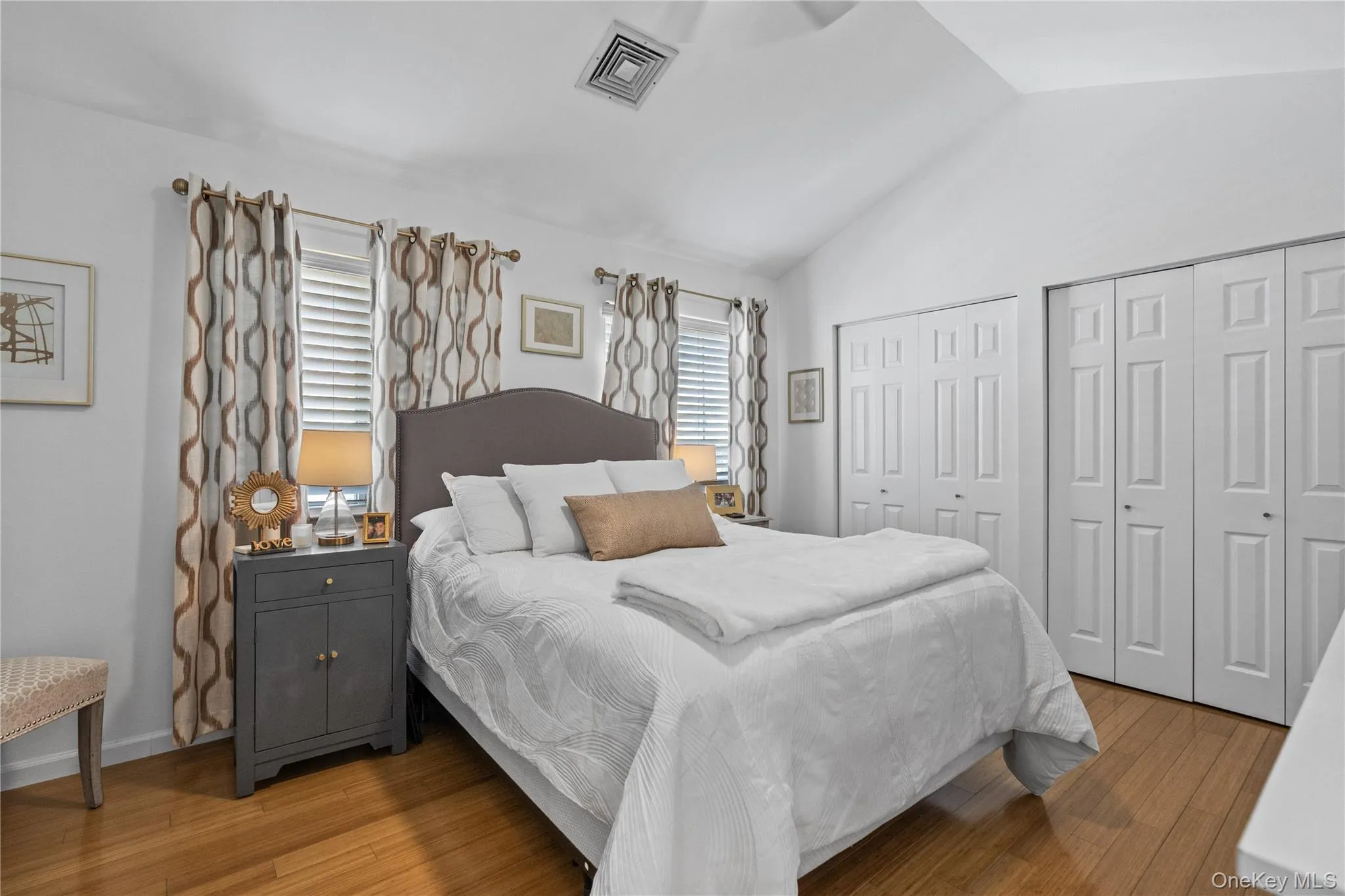Master bedroom with pitched ceiling and wall of closets Master bedroom with pitched ceiling and wall of closets