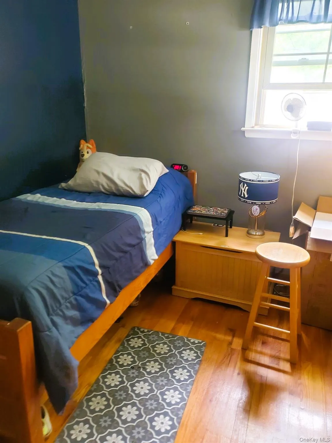 Room with a two-tone painted wall, wood-finish flooring, and corner windows with white trim Room with a two-tone painted wall, wood-finish flooring, and corner windows with white trim