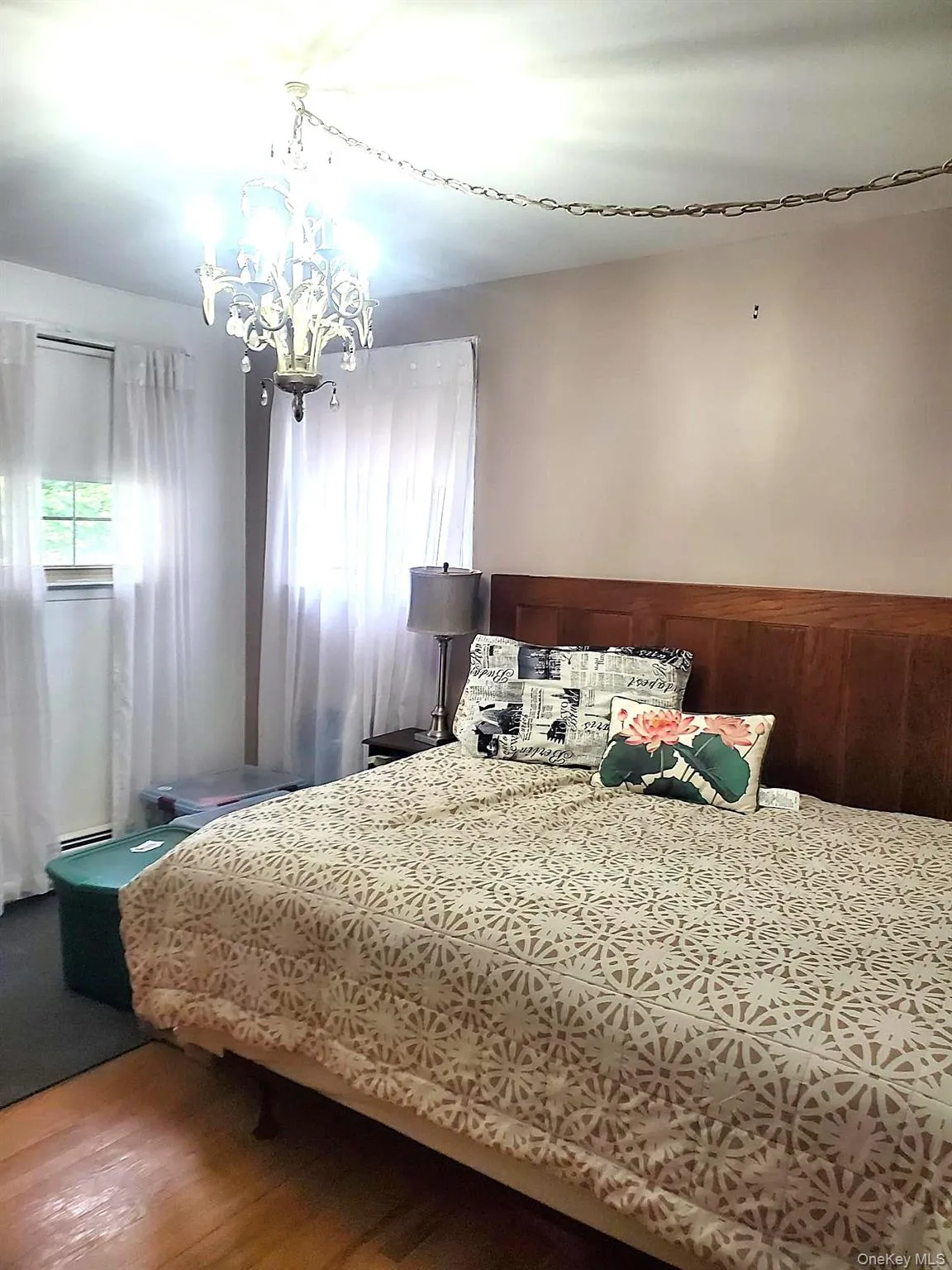 Hardwood flooring, two windows with white sheer curtains, recessed lighting, and a decorative chandelier Hardwood flooring, two windows with white sheer curtains, recessed lighting, and a decorative chandelier